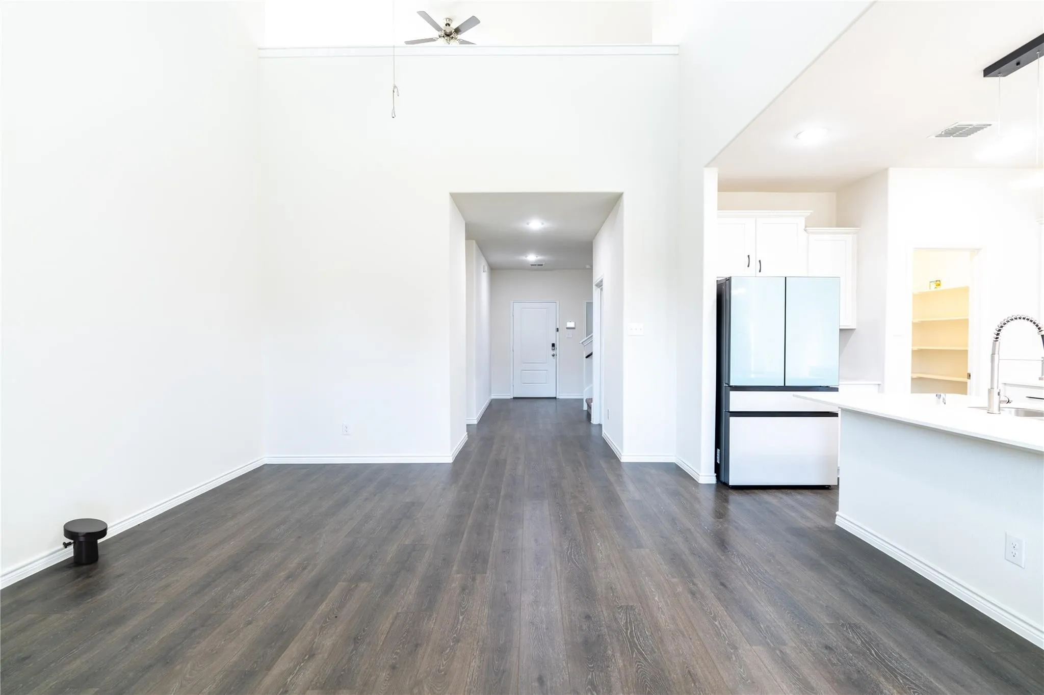 Spacious area featuring high ceilings, wood-finish flooring, recessed lighting, and a contemporary ceiling fan