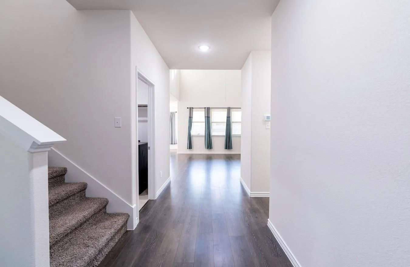 Foyer with wood-finish flooring, carpeted staircase, and recessed lighting