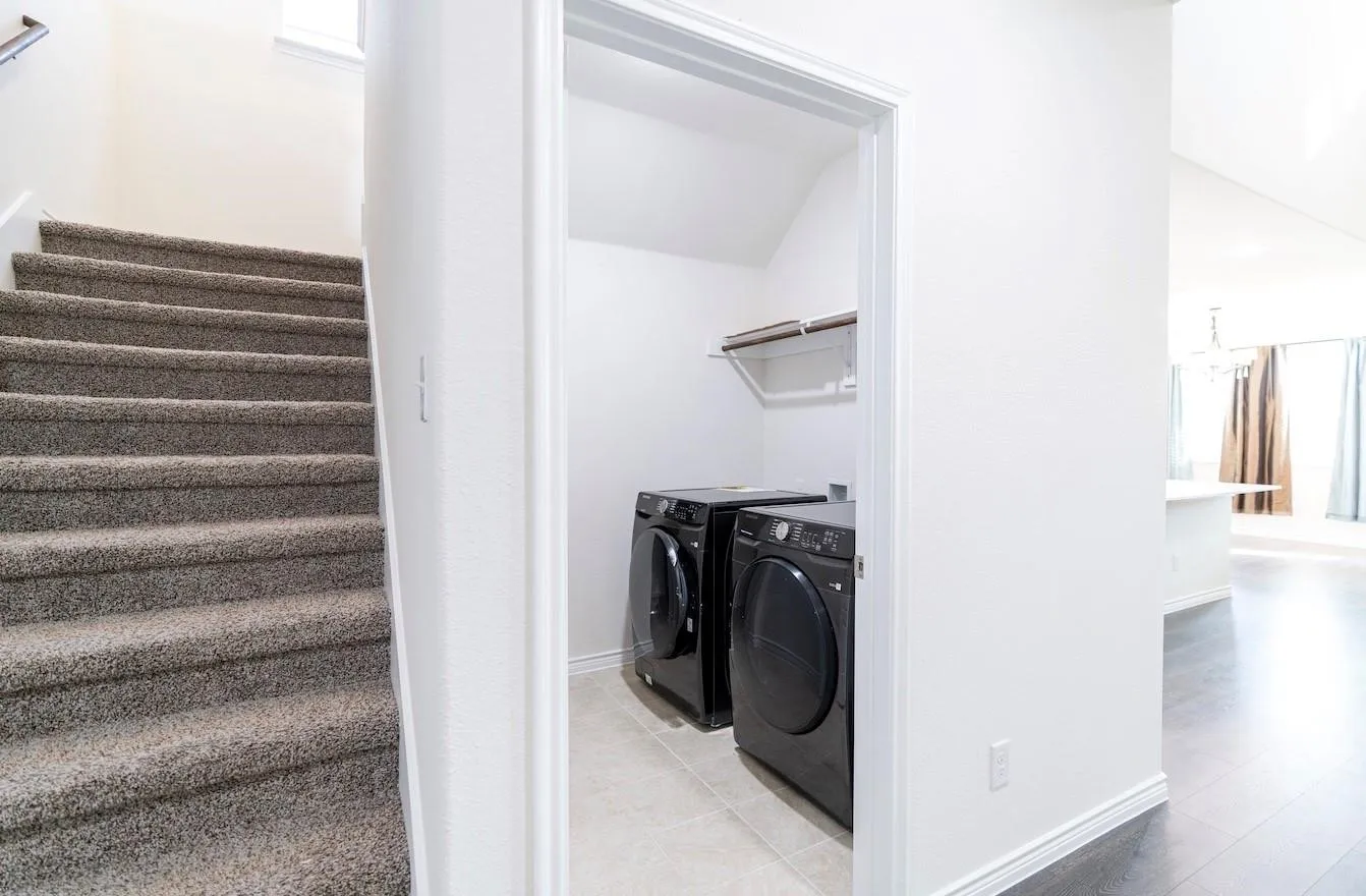 Dedicated laundry space featuring a built-in shelving unit and tiled flooring