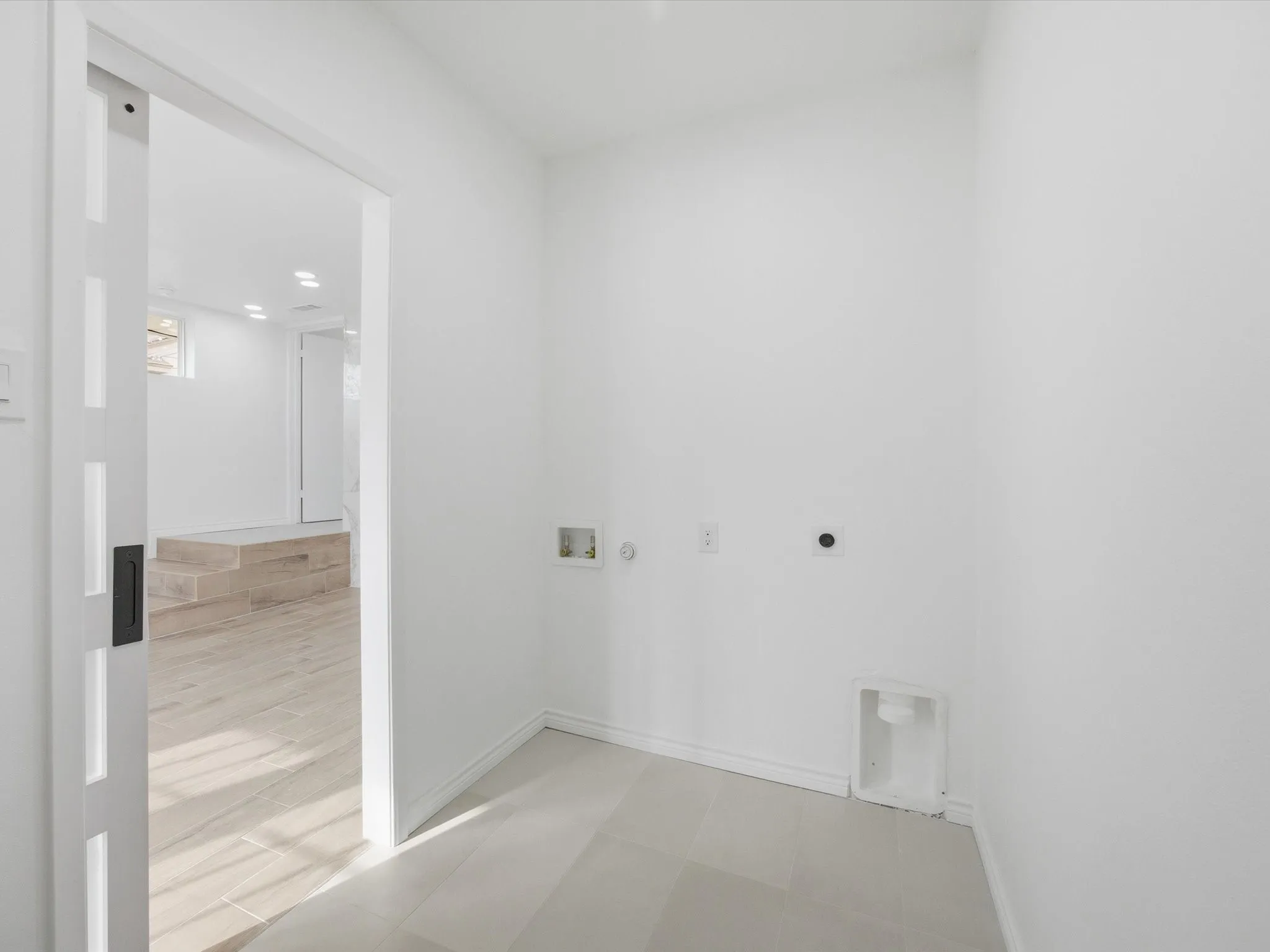 Laundry area featuring tile flooring and a sliding barn door
