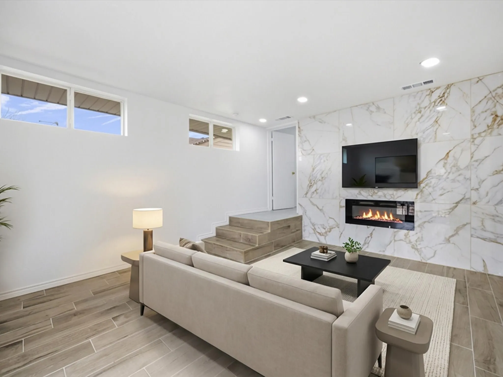 Living area featuring a floor-to-ceiling accent wall with a built-in linear fireplace, recessed lighting, and wood-finish tile flooring