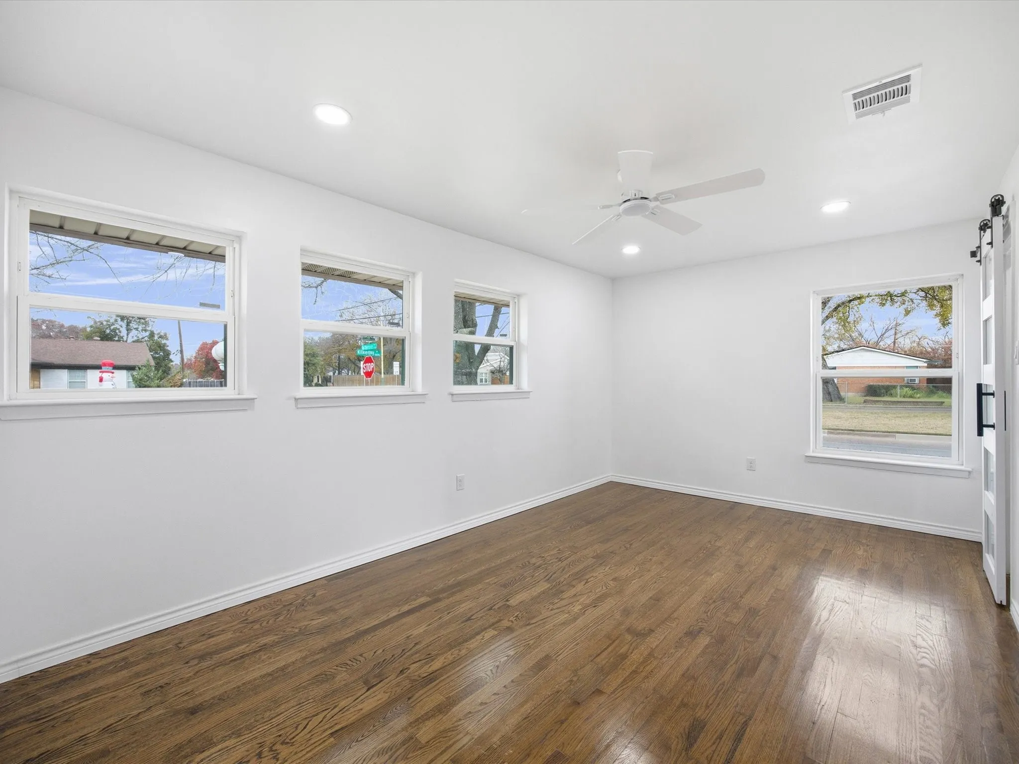 Hardwood-finish flooring, recessed lighting, and a ceiling fan