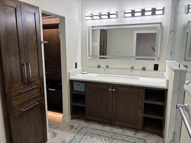 Dual vanity with integrated sinks, wall-mounted faucets, lots of storage, and white quartz countertop