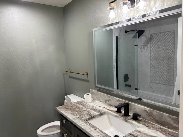 Upstairs bath with a unique veined countertop, rectangular undermount sink, and matte black fixtures