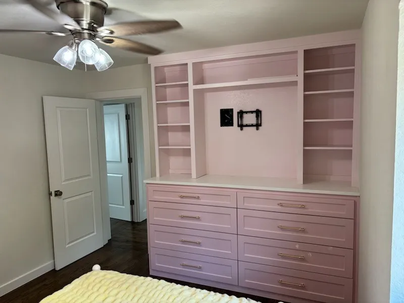 Built-in storage cabinetry with open shelving, integrated drawers, and a light-toned countertop