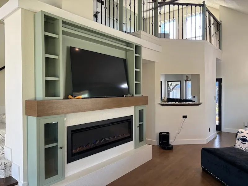 Built-in entertainment center with integrated electric fireplace and custom wood-finish mantel and quartz hearth