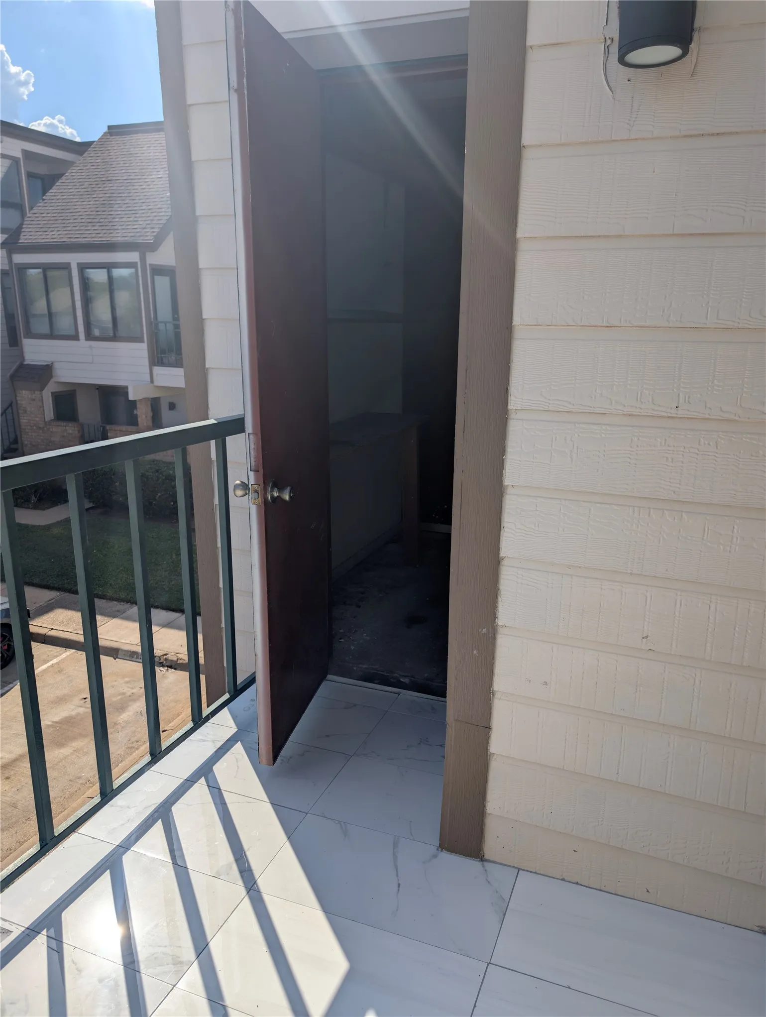 Balcony with light-toned tiled flooring and dark metal railing