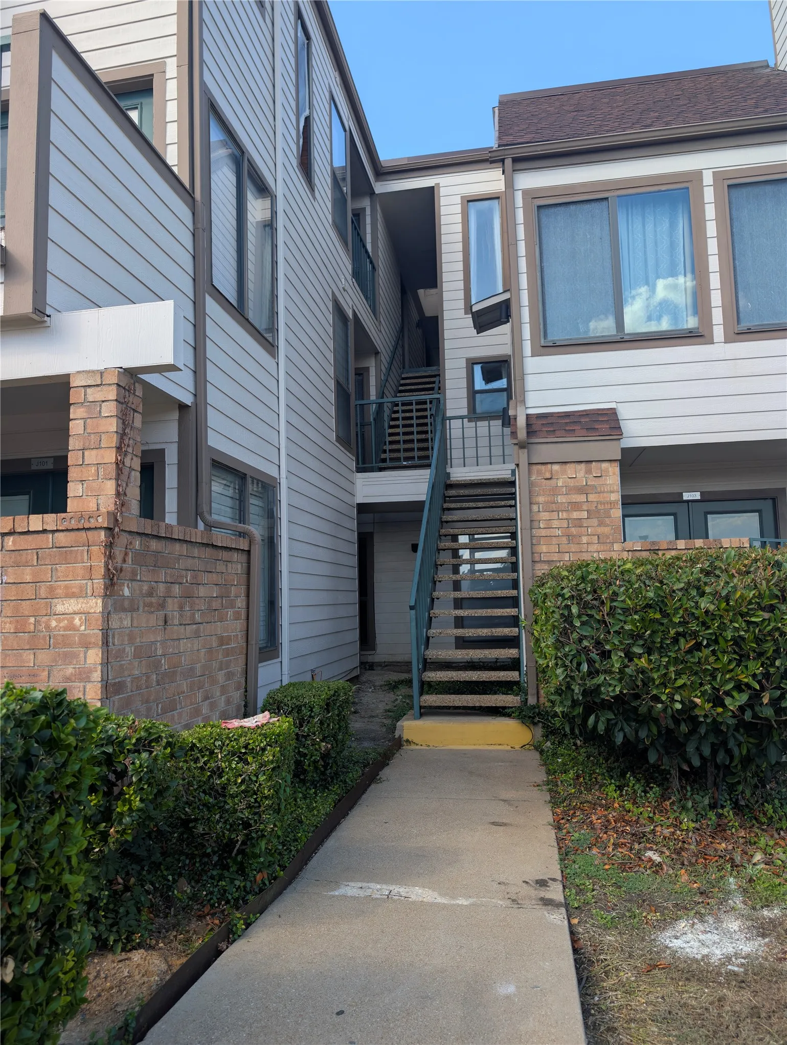 Multi-story exterior with horizontal siding and brick accents
