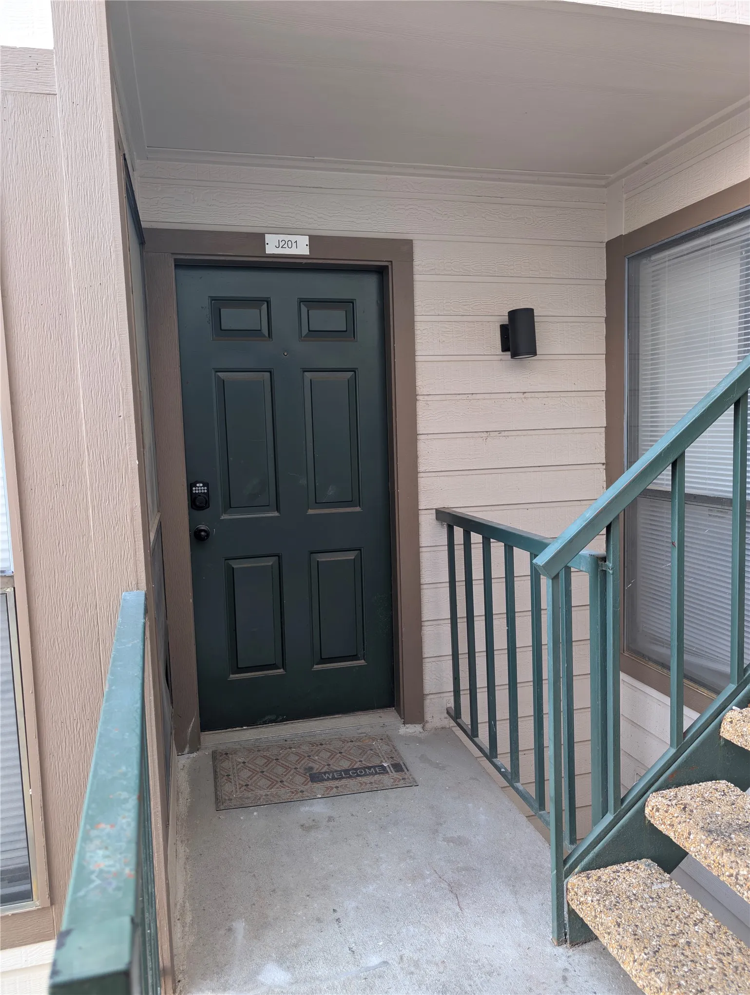 Entry with panel door, wall-mounted light fixture, and adjacent window