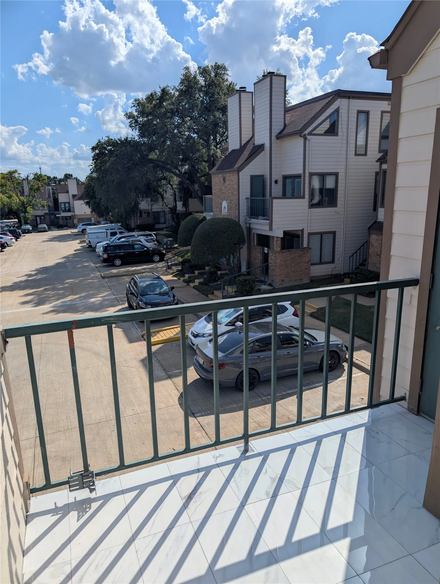 Balcony with tile flooring and a green metal railing