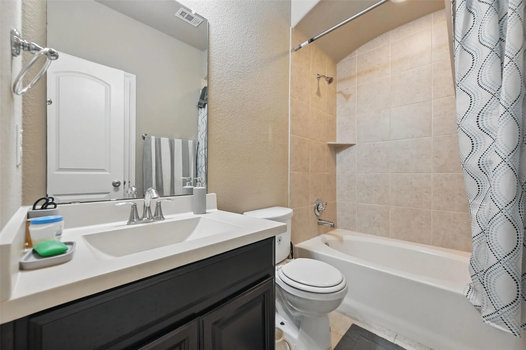 Vanity with an integrated sink, polished chrome faucet, and dark wood-finish cabinetry