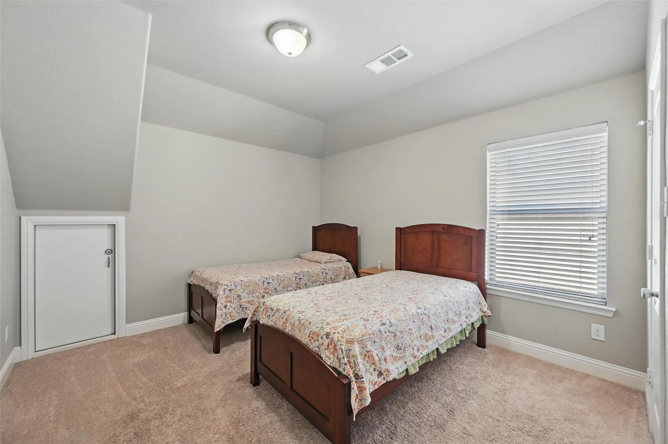 Carpeted flooring, vaulted ceiling with recessed lighting, and a window with horizontal blinds