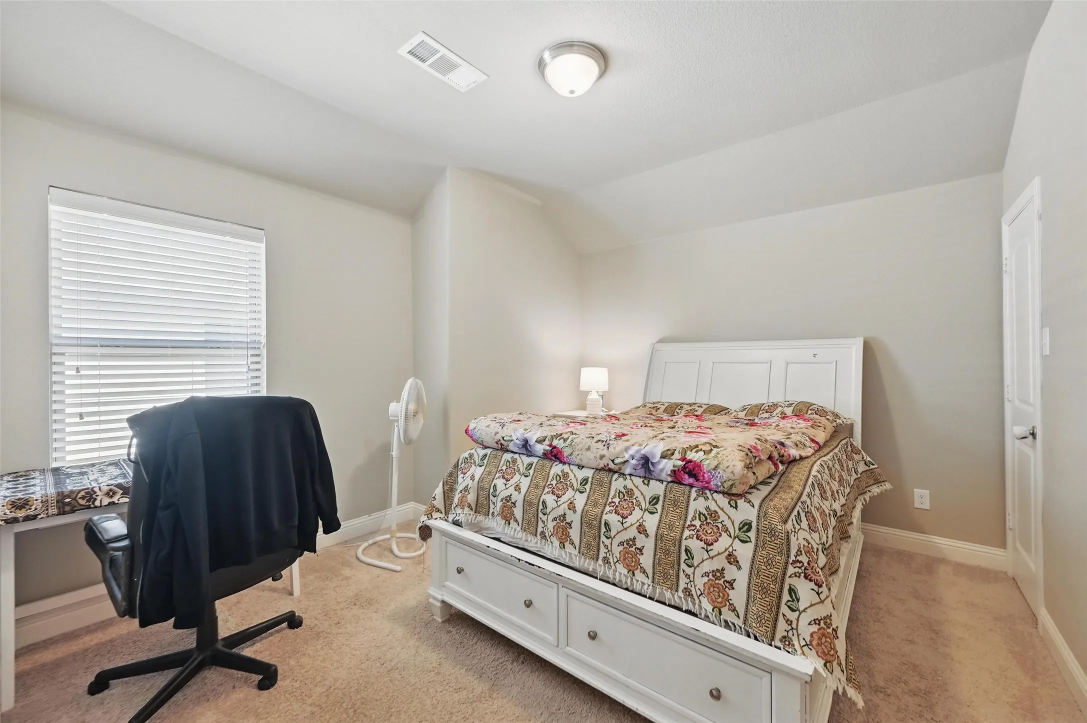 Carpeted room with a ceiling-mounted light fixture, a window with blinds, and light-toned walls