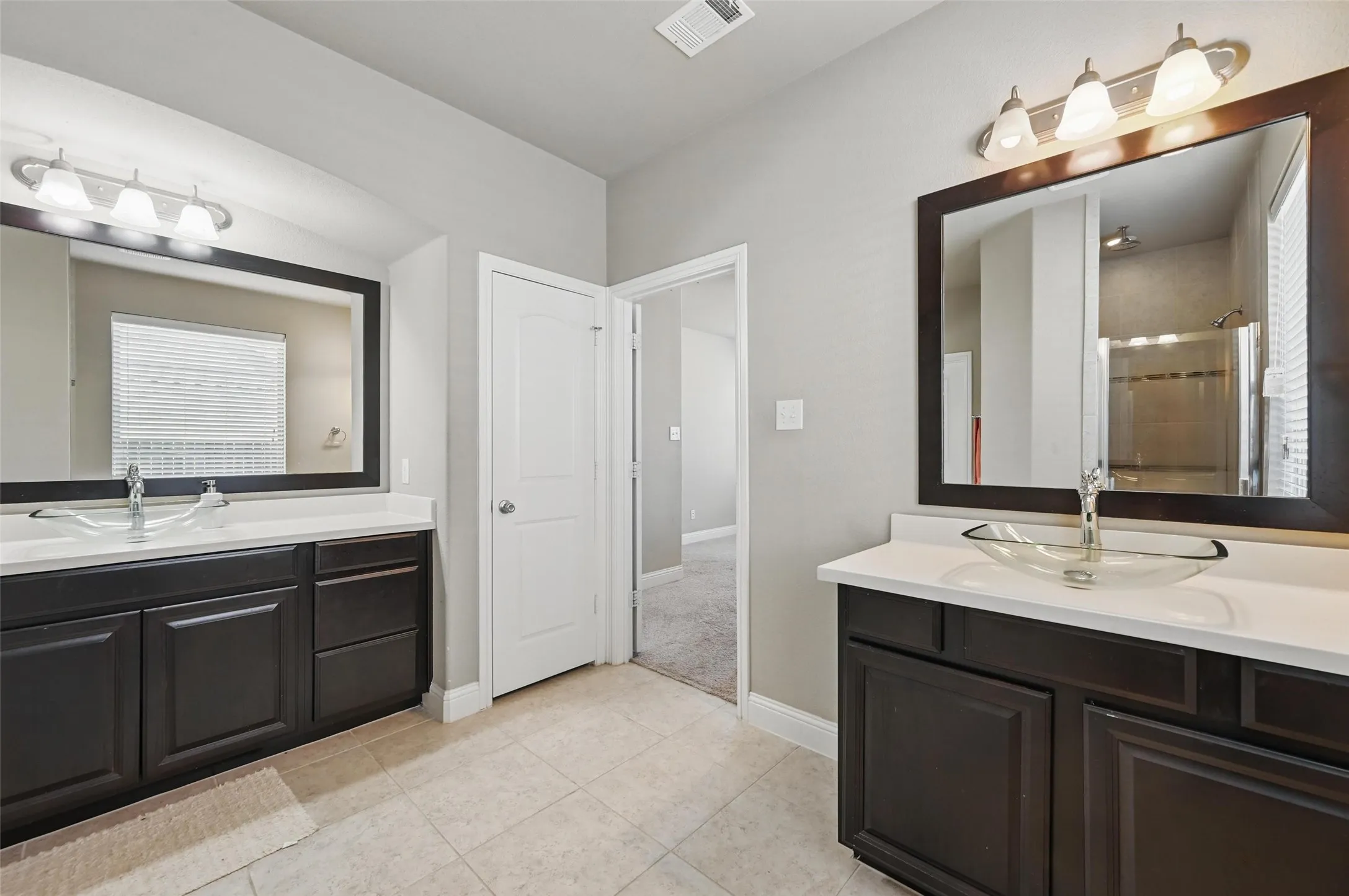 Dual dark wood-finish vanities with light countertops