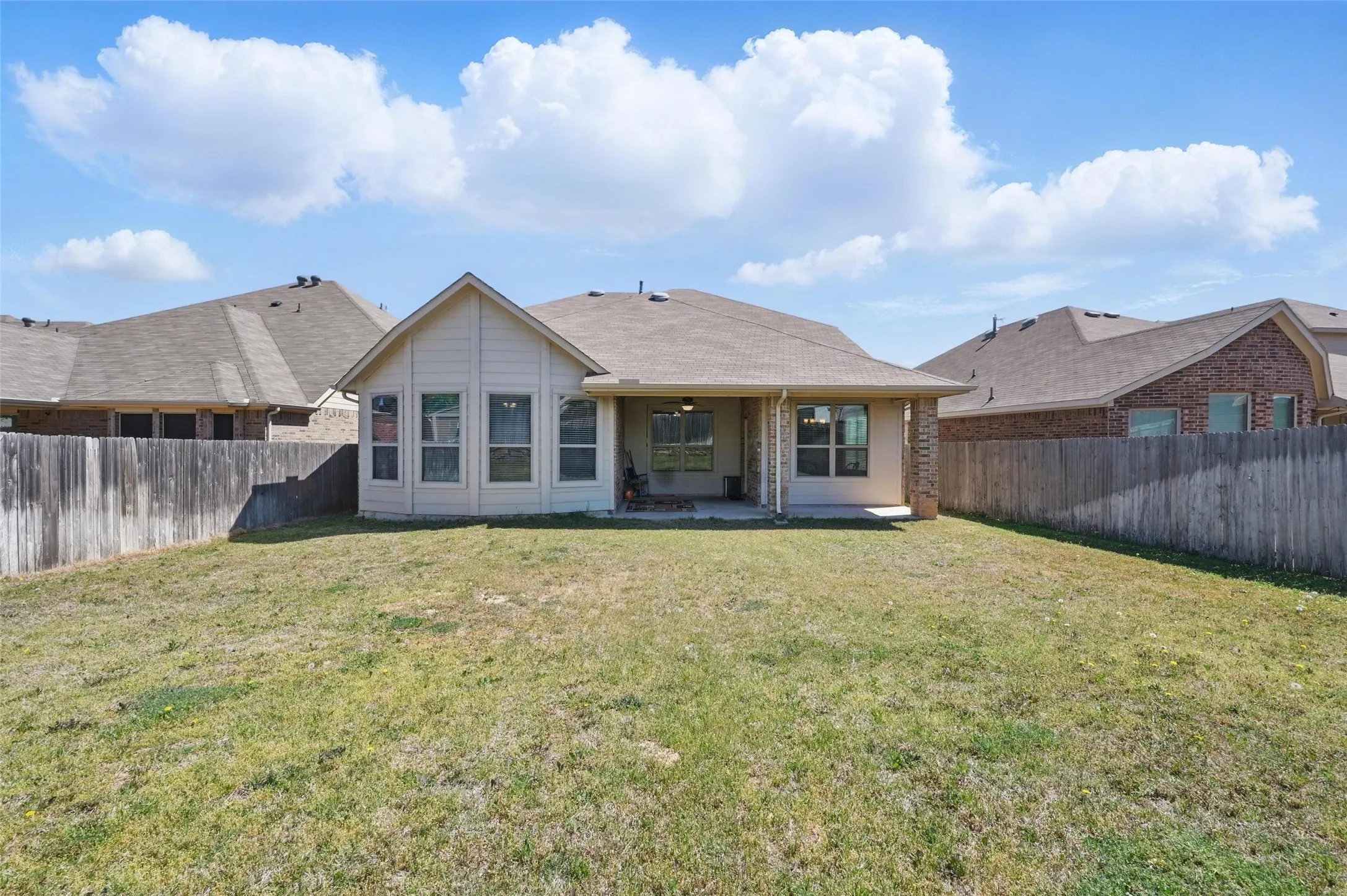Expansive grassy lawn with a wood privacy fence