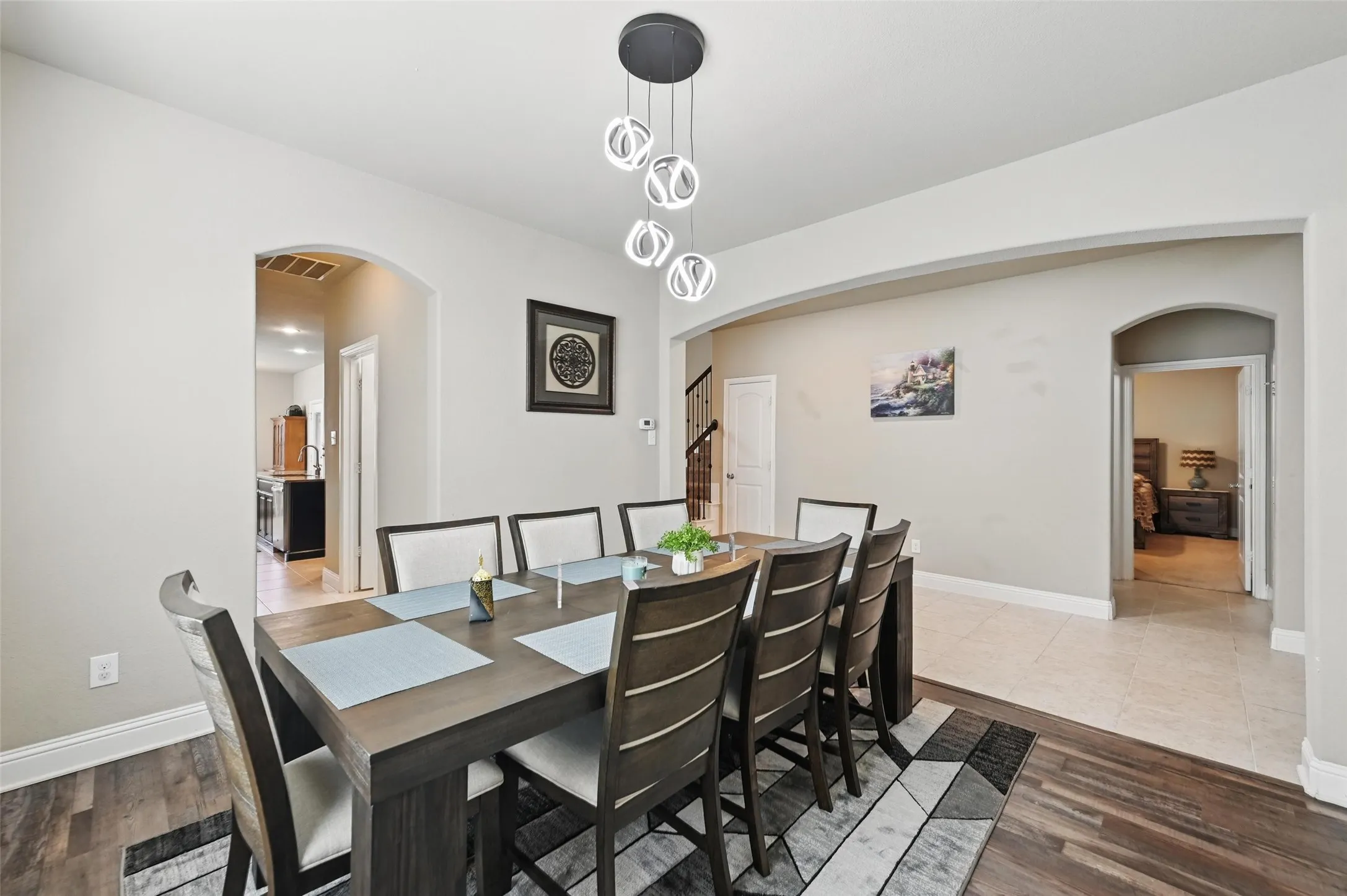 Dining area featuring wood-finish flooring, recessed lighting, and arched doorways