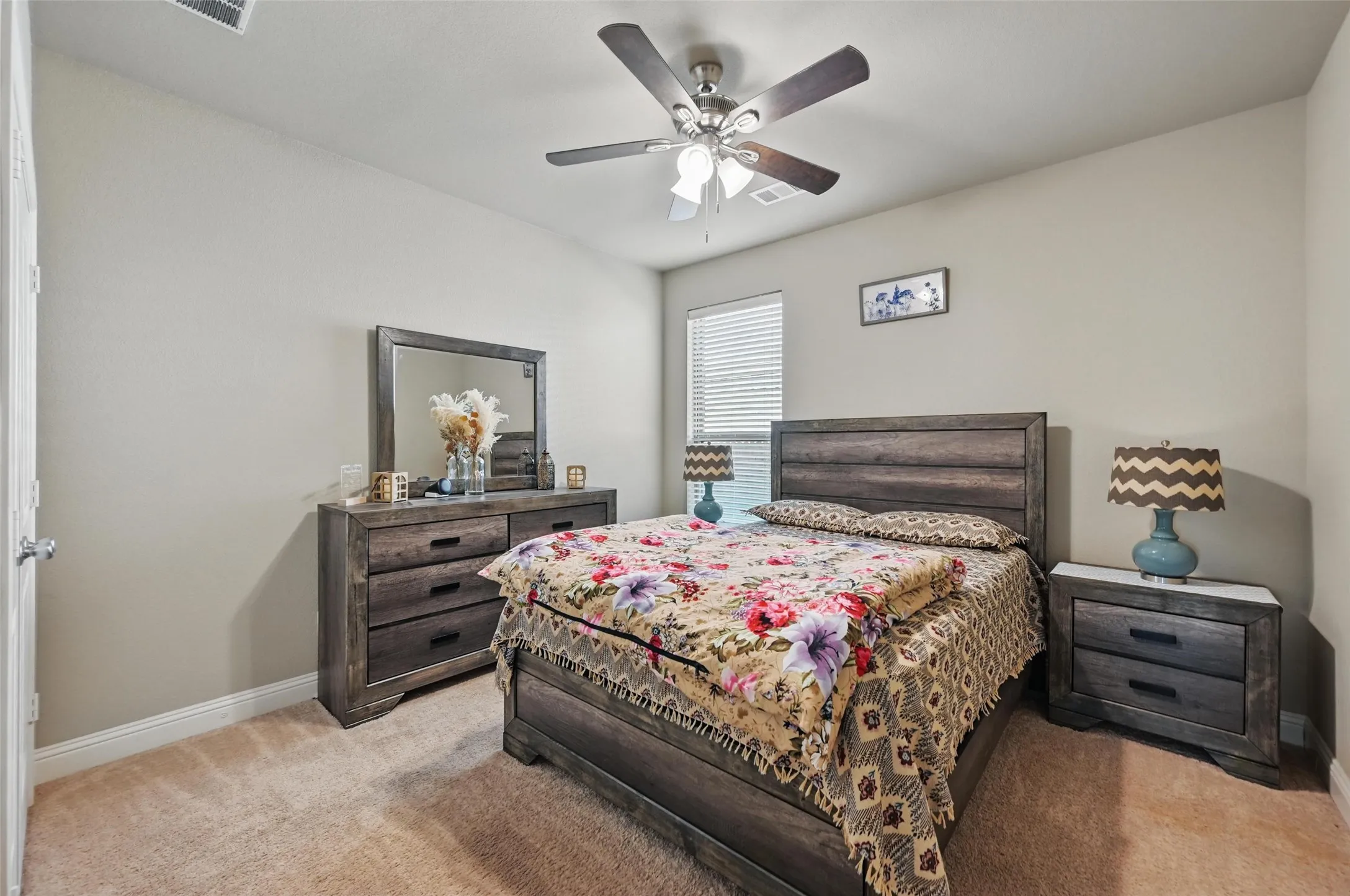Vaulted ceiling, ceiling fan with integrated lighting, window with blinds, light neutral wall color, and carpet flooring