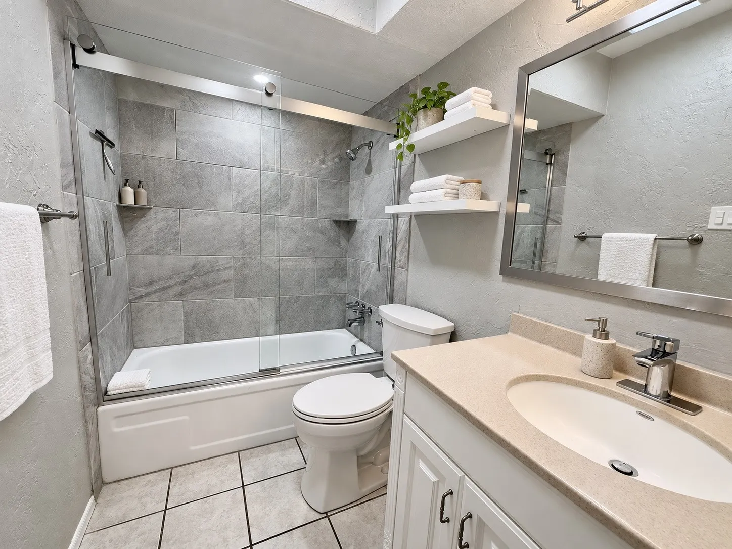2 Primary Bedrooms/Baths to choose from.  This one has a Tub and shower combination with sliding glass doors, integrated shelving, and tile surround
