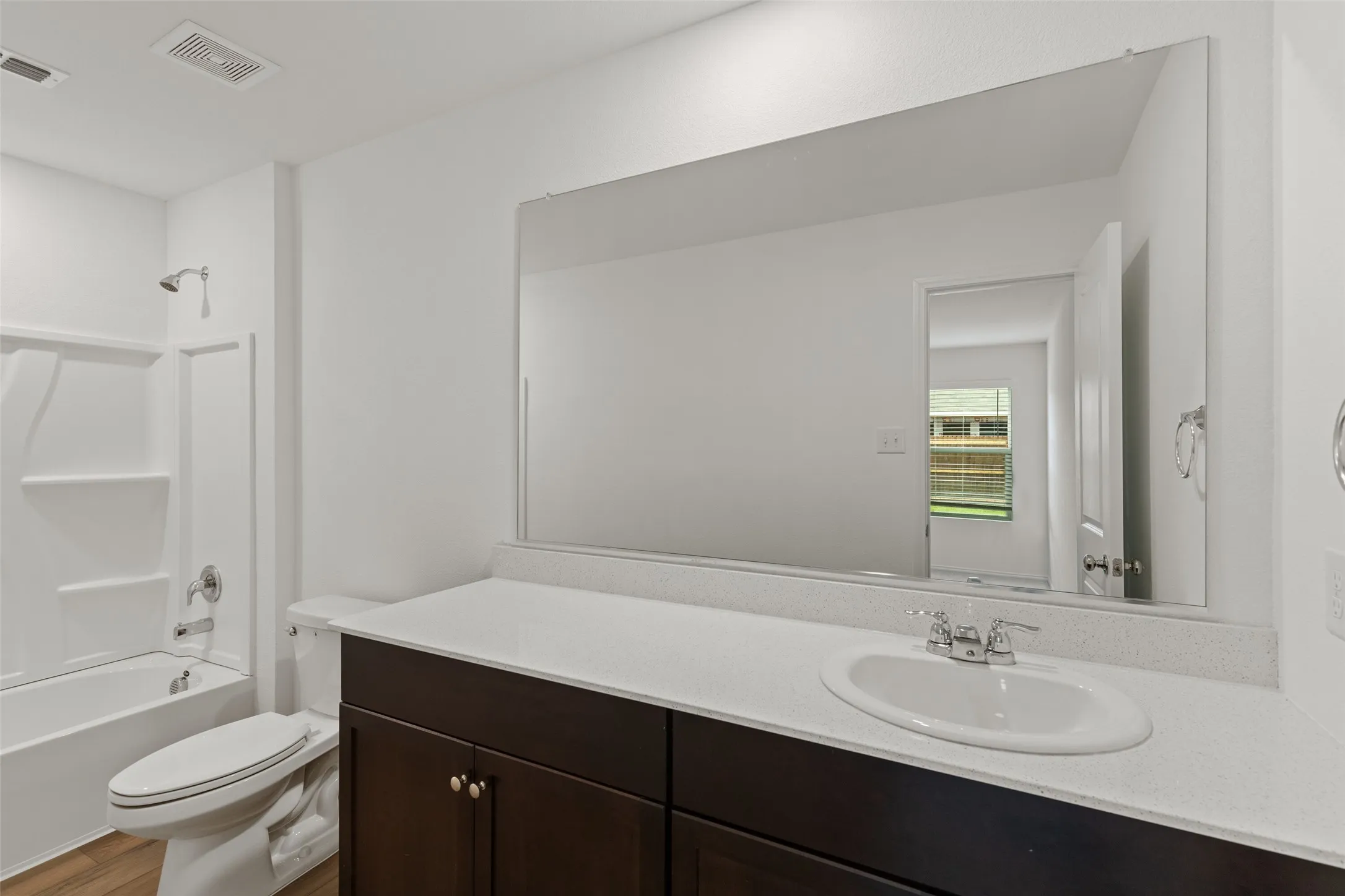 White bathtub with built-in shelving and chrome fixtures