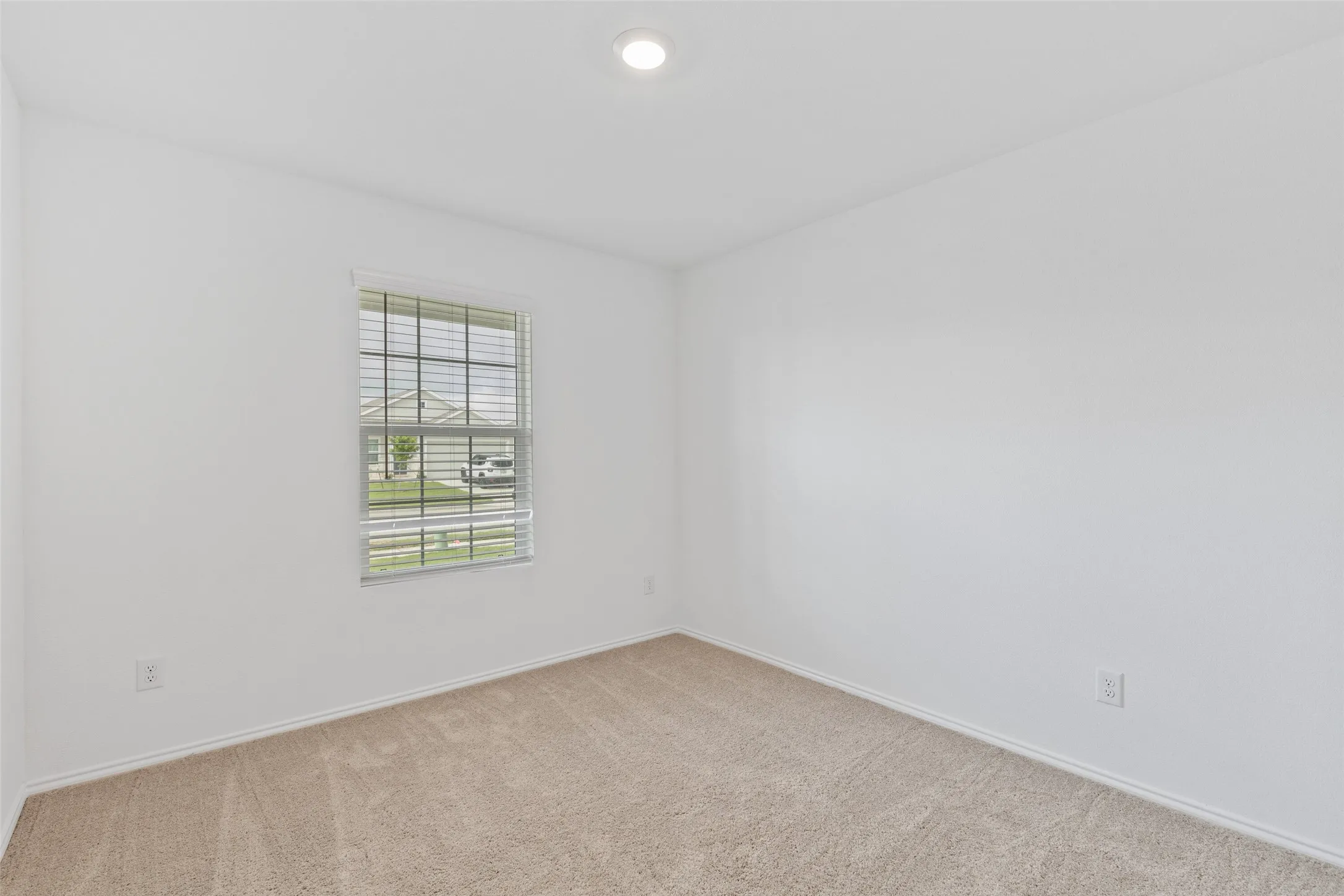 Recessed ceiling light, neutral wall paint, single window, window blinds, and carpeted flooring