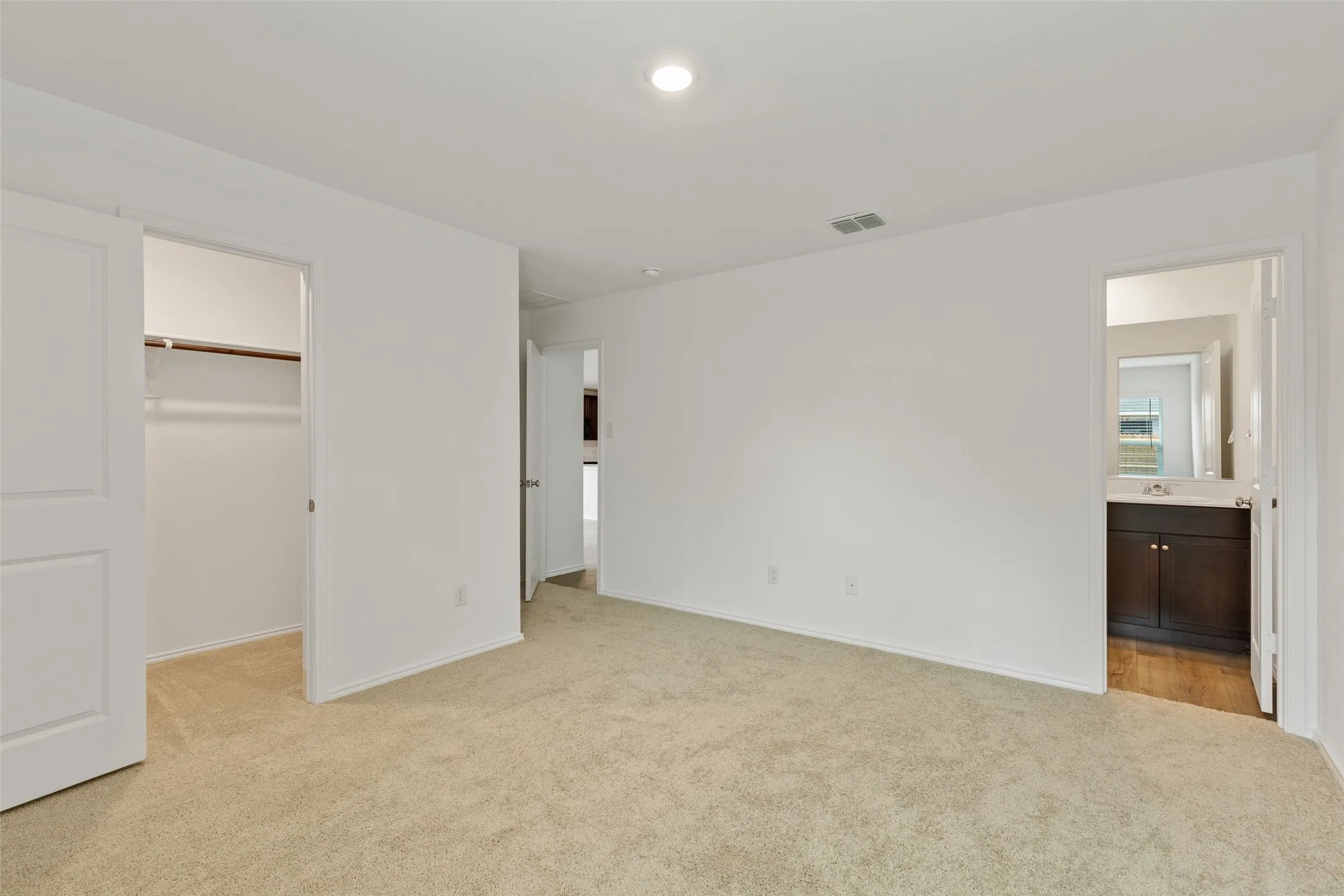 Neutral tone carpeting and white walls with a built-in closet featuring bi-fold doors