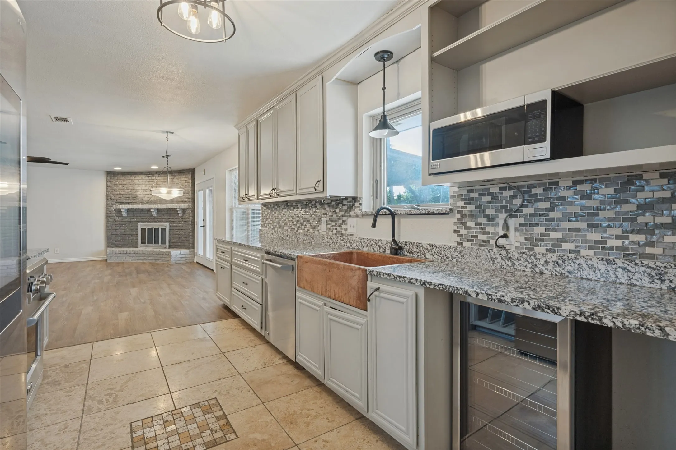 Kitchen featuring light-finish cabinetry, granite countertops, and a mosaic tile backsplash