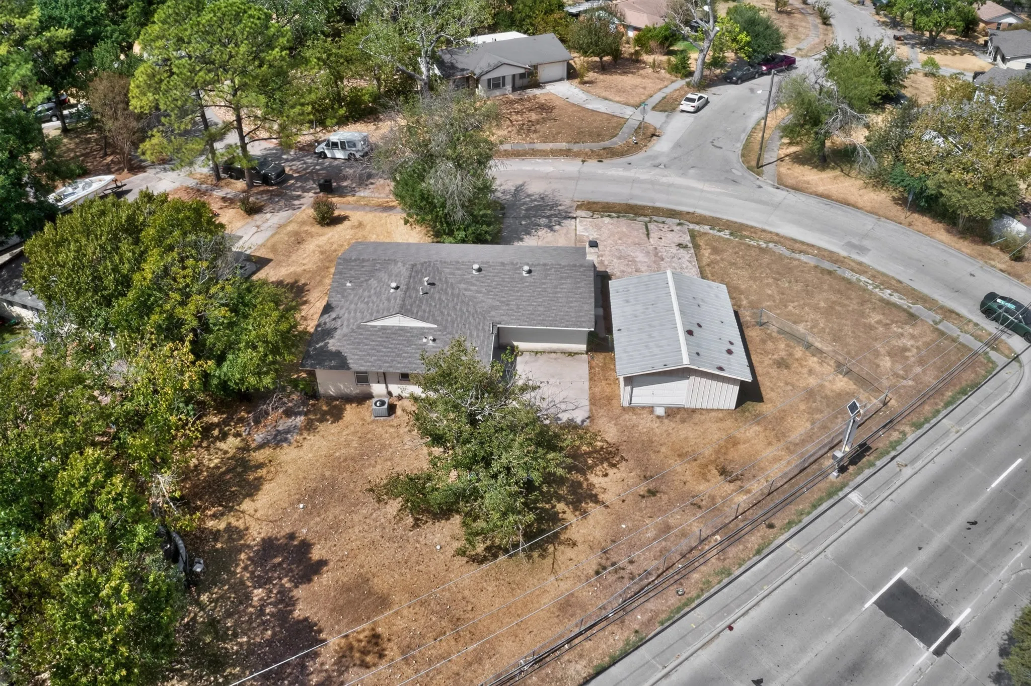 Single-story residence with a gray shingle roof, attached garage, and a detached outbuilding