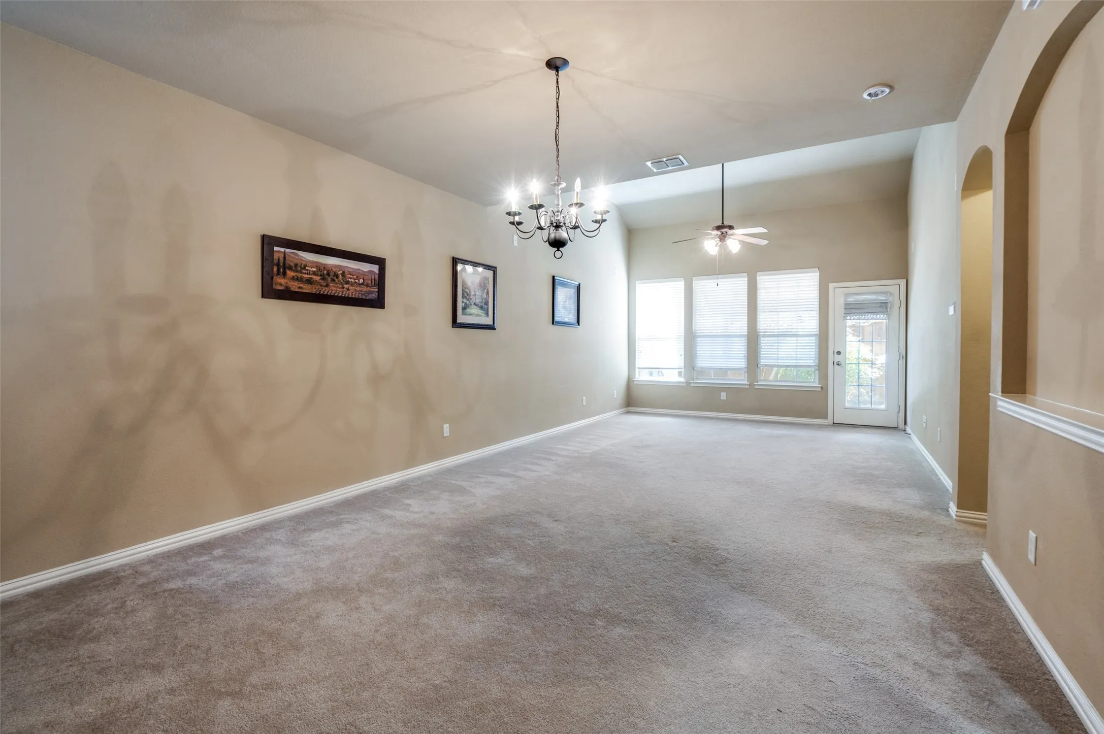 Vaulted ceiling, recessed lighting, ceiling fan, carpet flooring, and arched doorway