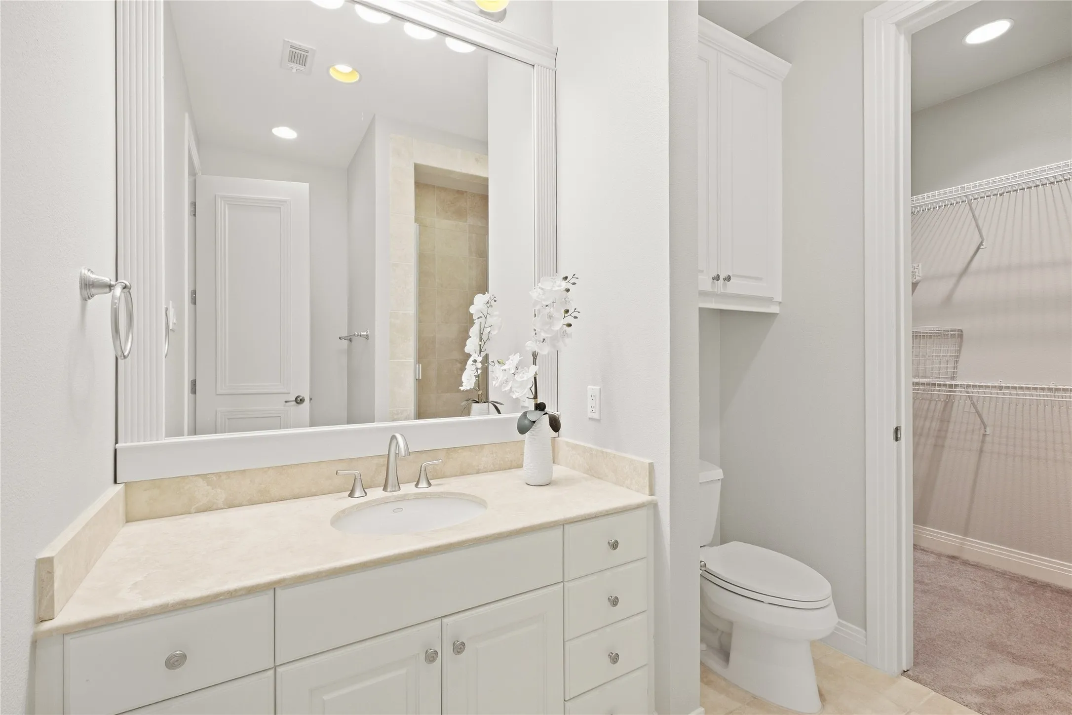 An en-suite bath serves the second bedroom on the top floor, with a travertine vanity and walk-in closet.