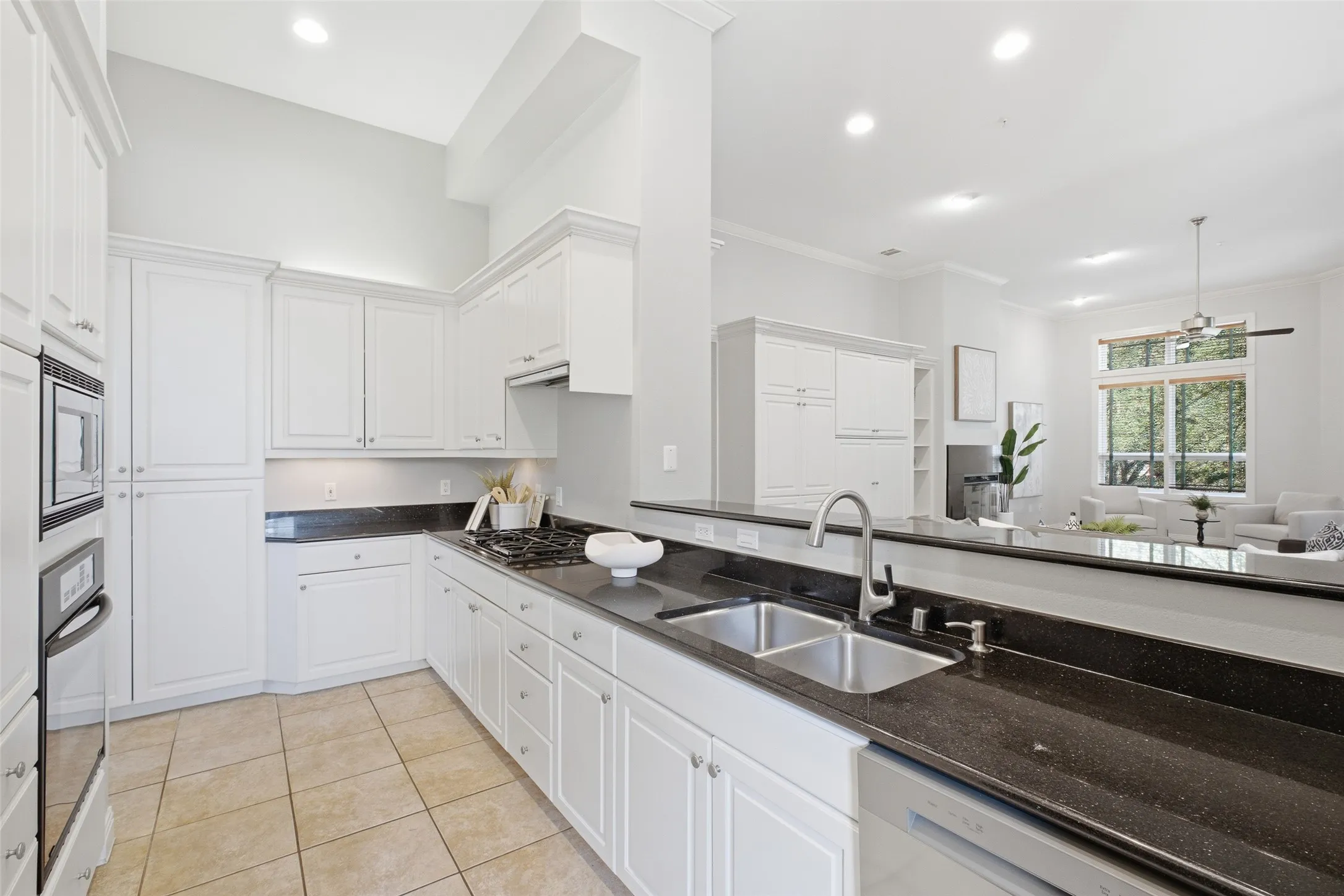 White cabinetry, granite counters, a gas cooktop, and a built-in oven - a kitchen that works