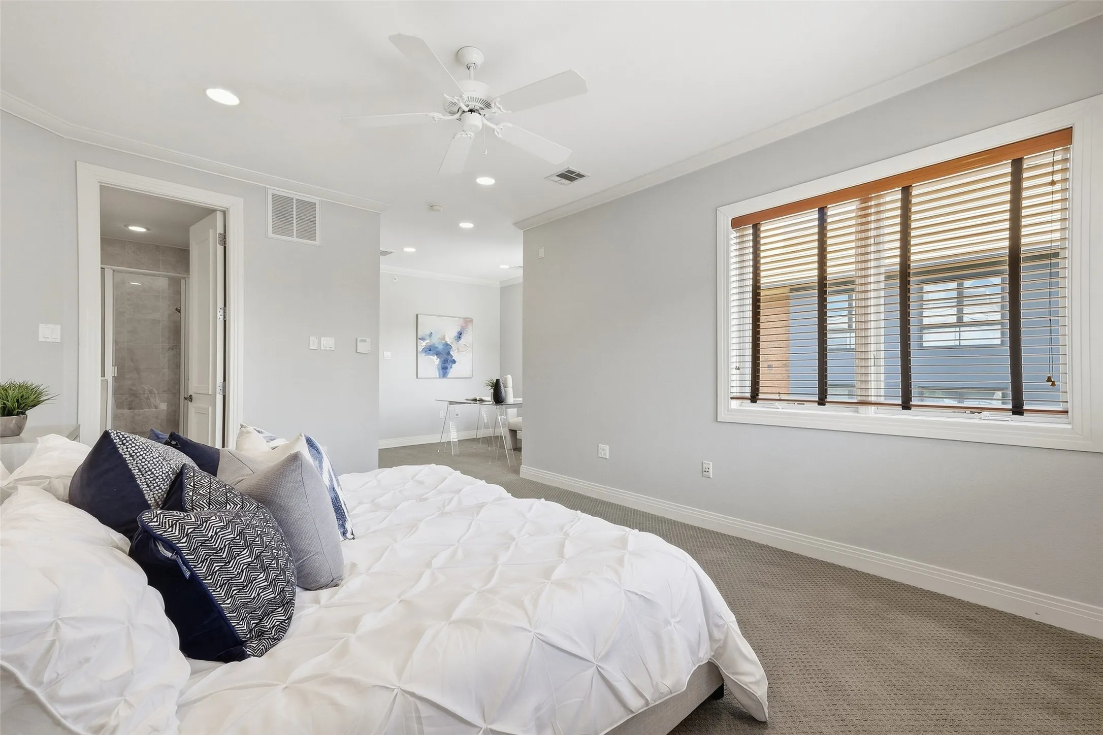 Windows on two walls keep the primary suite bright from sunrise straight through sunset
