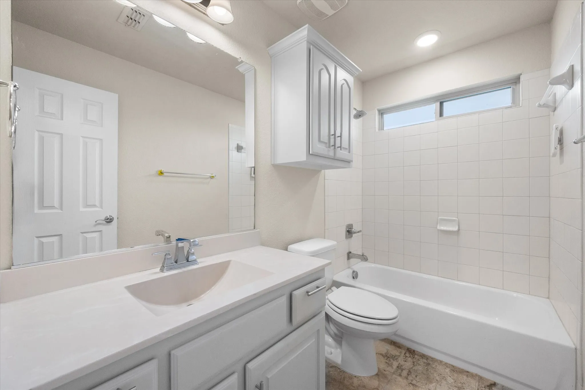 Vanity with integrated sink, white cabinetry, and polished chrome fixtures