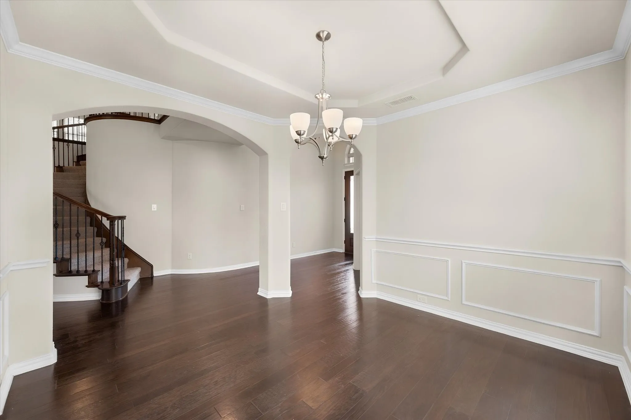 Dark wood-finish flooring with wainscoting and crown molding