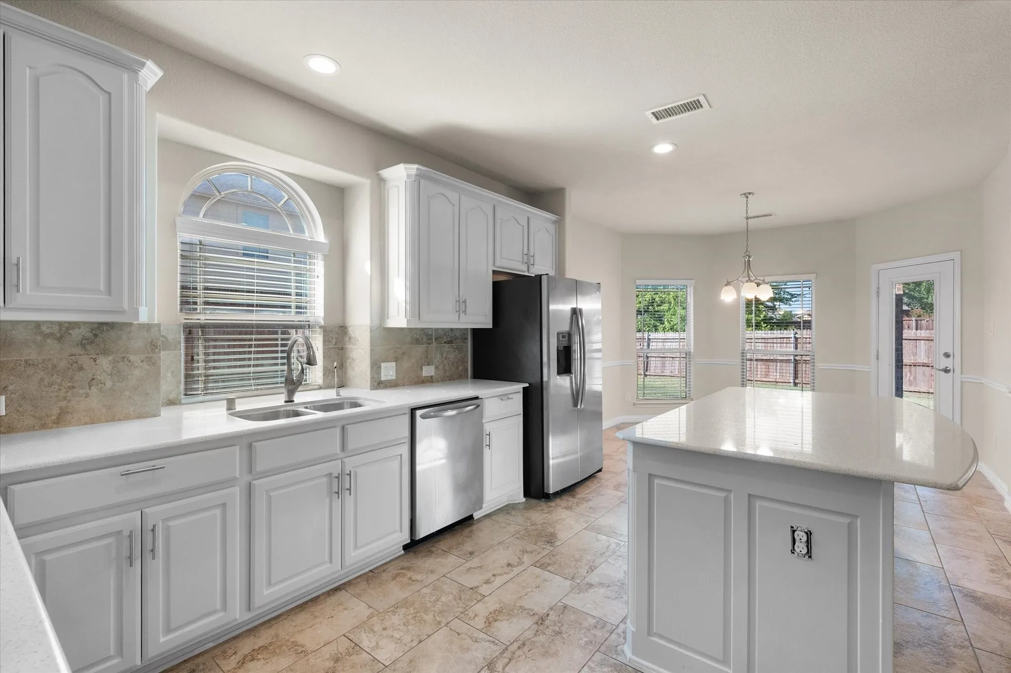 Kitchen featuring white cabinetry, light-toned countertops, stainless steel appliances, and tile flooring
