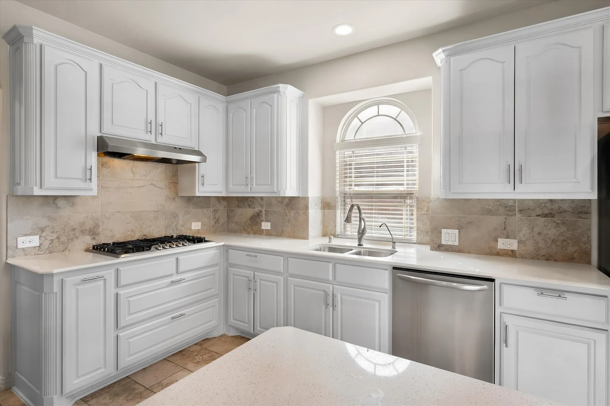 Kitchen featuring white cabinetry, stone-finish countertops, stainless steel appliances, a gas cooktop, and a tile backsplash