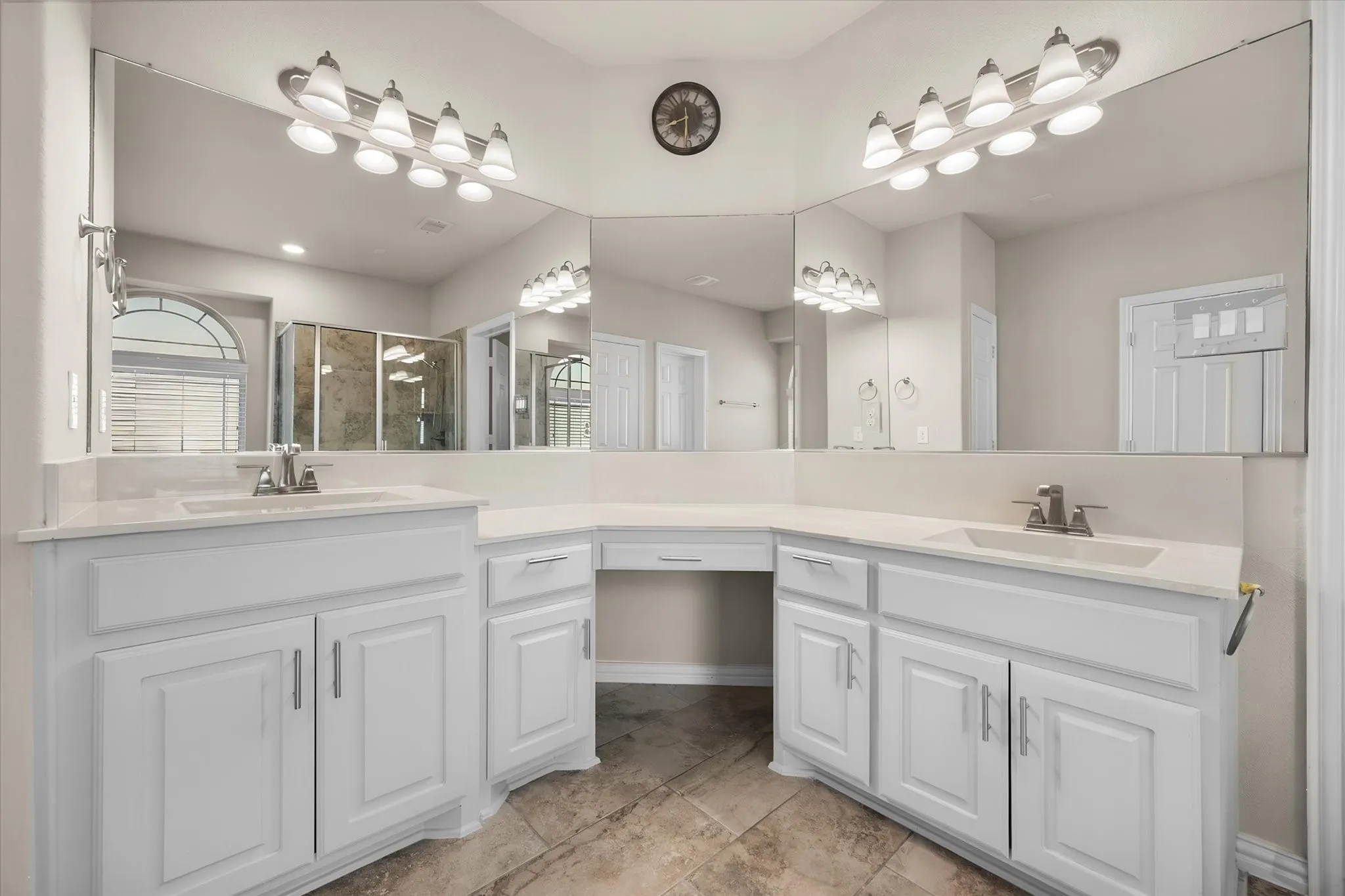 Dual vanities with white cabinetry, light-toned countertops, and undermount sinks