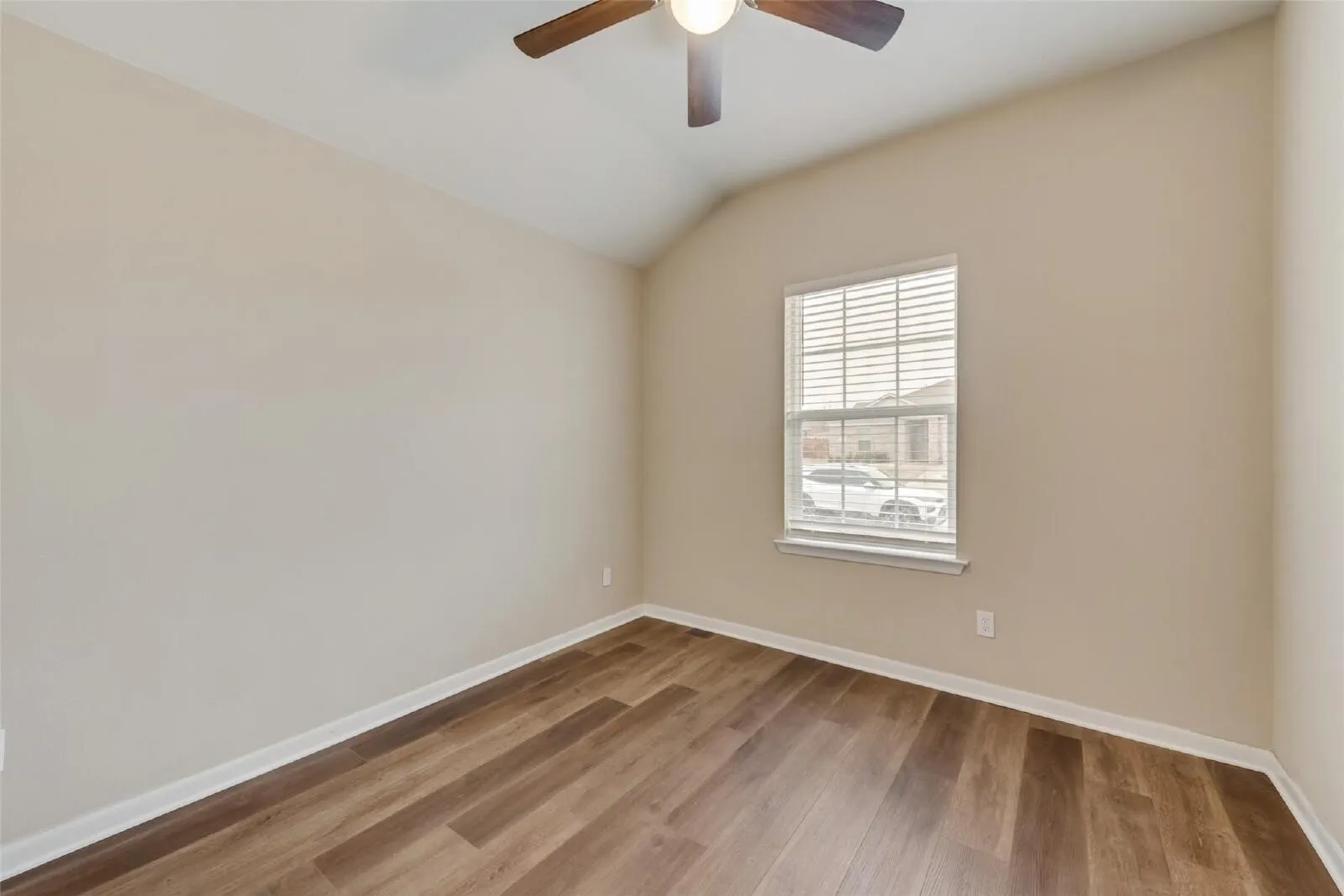 Vaulted ceiling with a ceiling fan, wood-finish flooring, and window with blinds