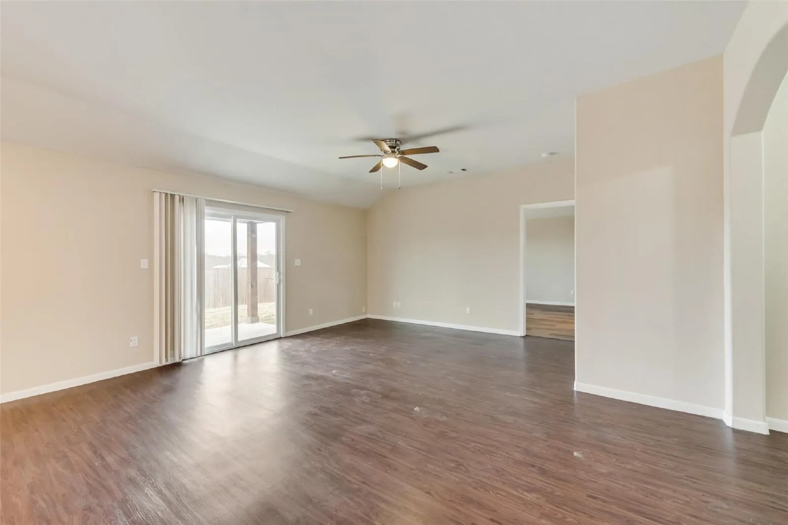 Spacious interior with wood-finish flooring, vaulted ceiling, and ceiling fan