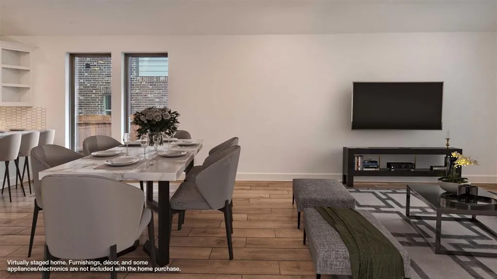 Wood-finish flooring throughout, with a built-in wall niche featuring shelving, and a tiled backsplash in the kitchen area