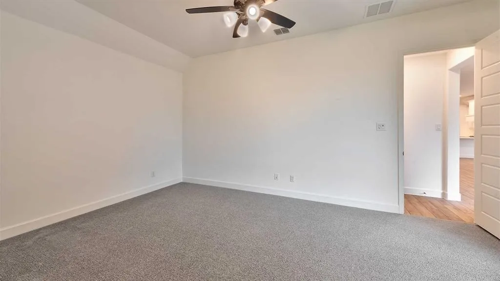 Neutral wall finishes, recessed ceiling, gray carpet, and a ceiling fan