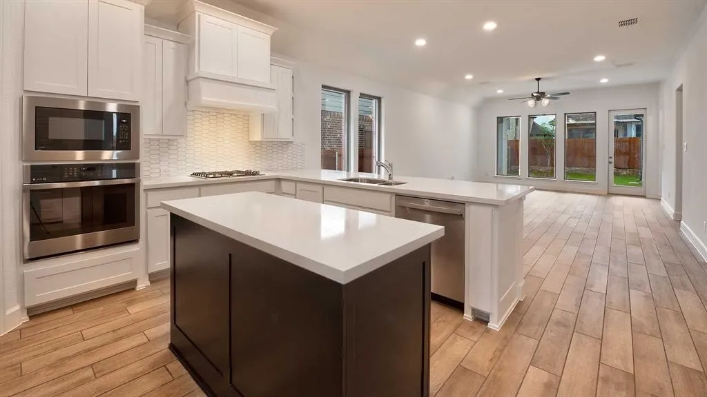 Kitchen featuring dual islands, recessed lighting, and a stainless steel appliance suite with a wall oven and microwave