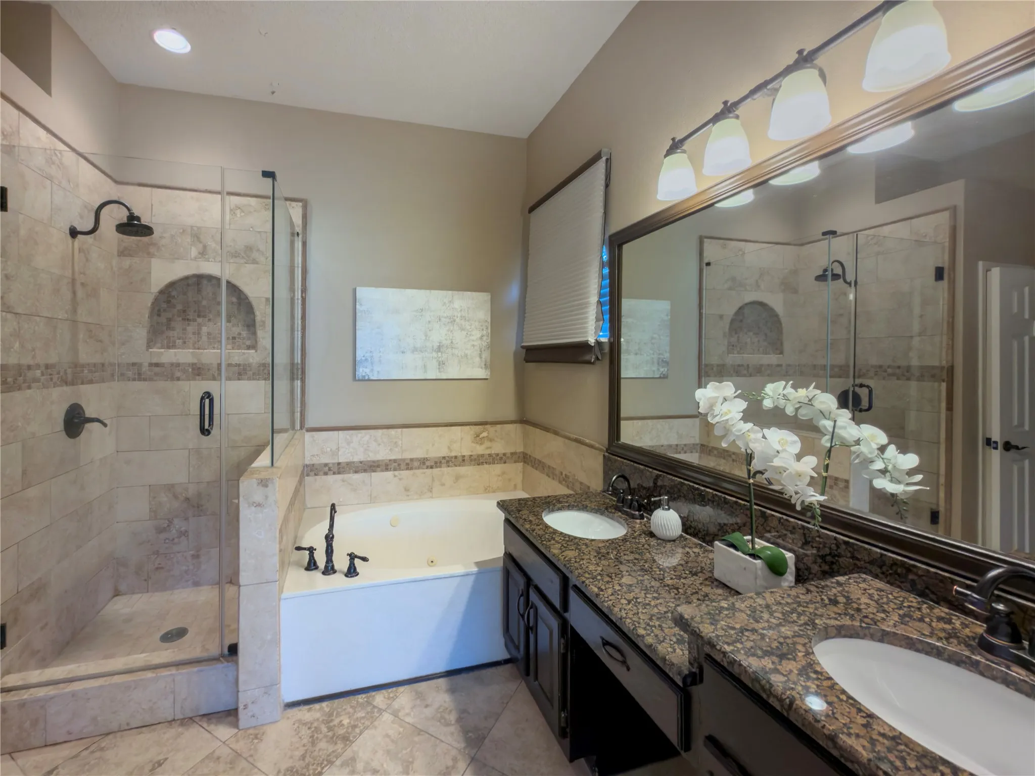 Glass-enclosed shower with tile surround and integrated niche