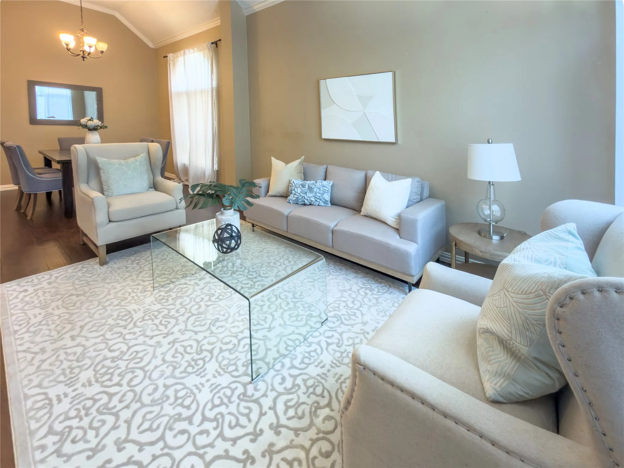 Vaulted ceiling, wood-finish flooring, crown molding, and a chandelier lighting fixture