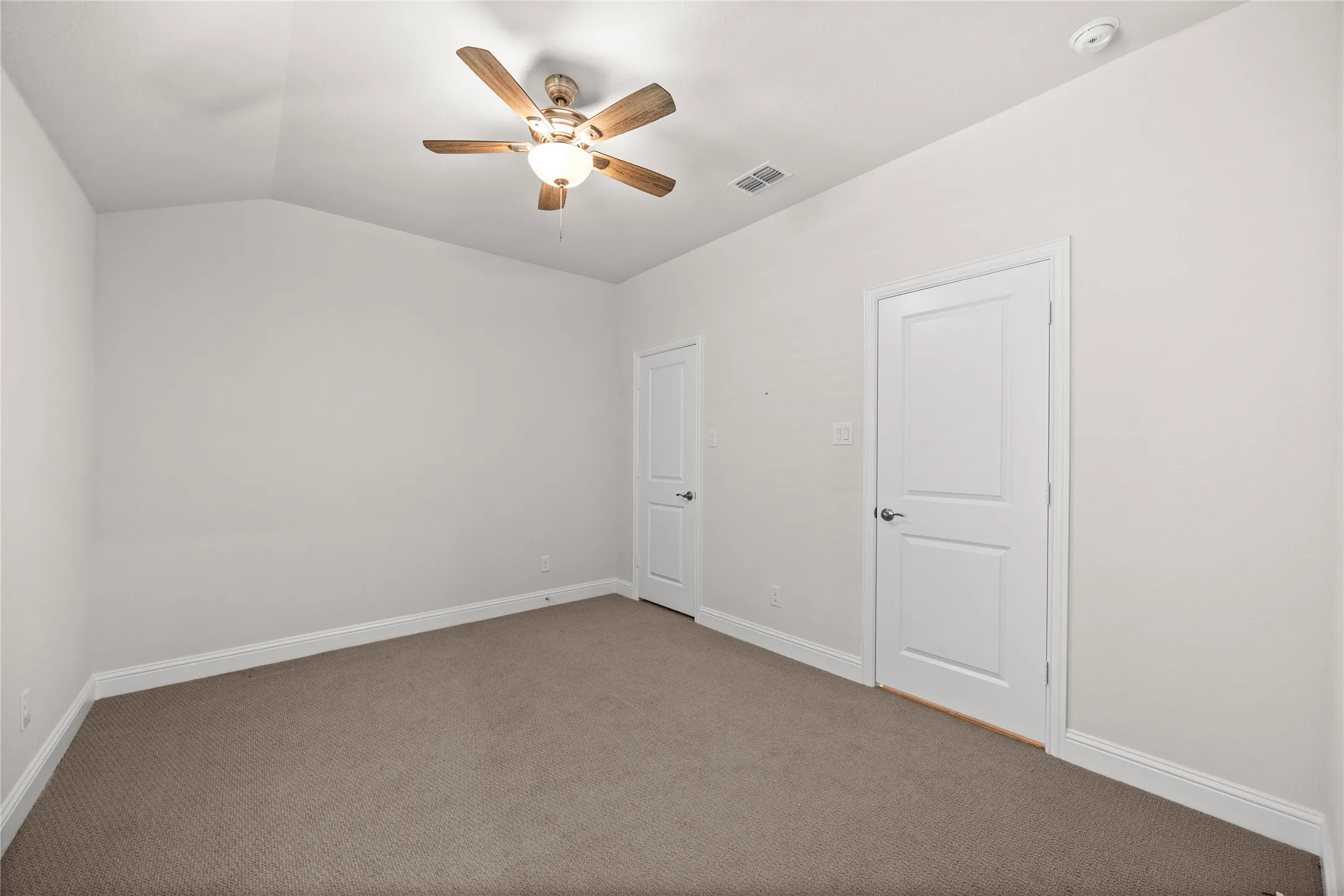 Vaulted ceiling with an attached ceiling fan and light fixture