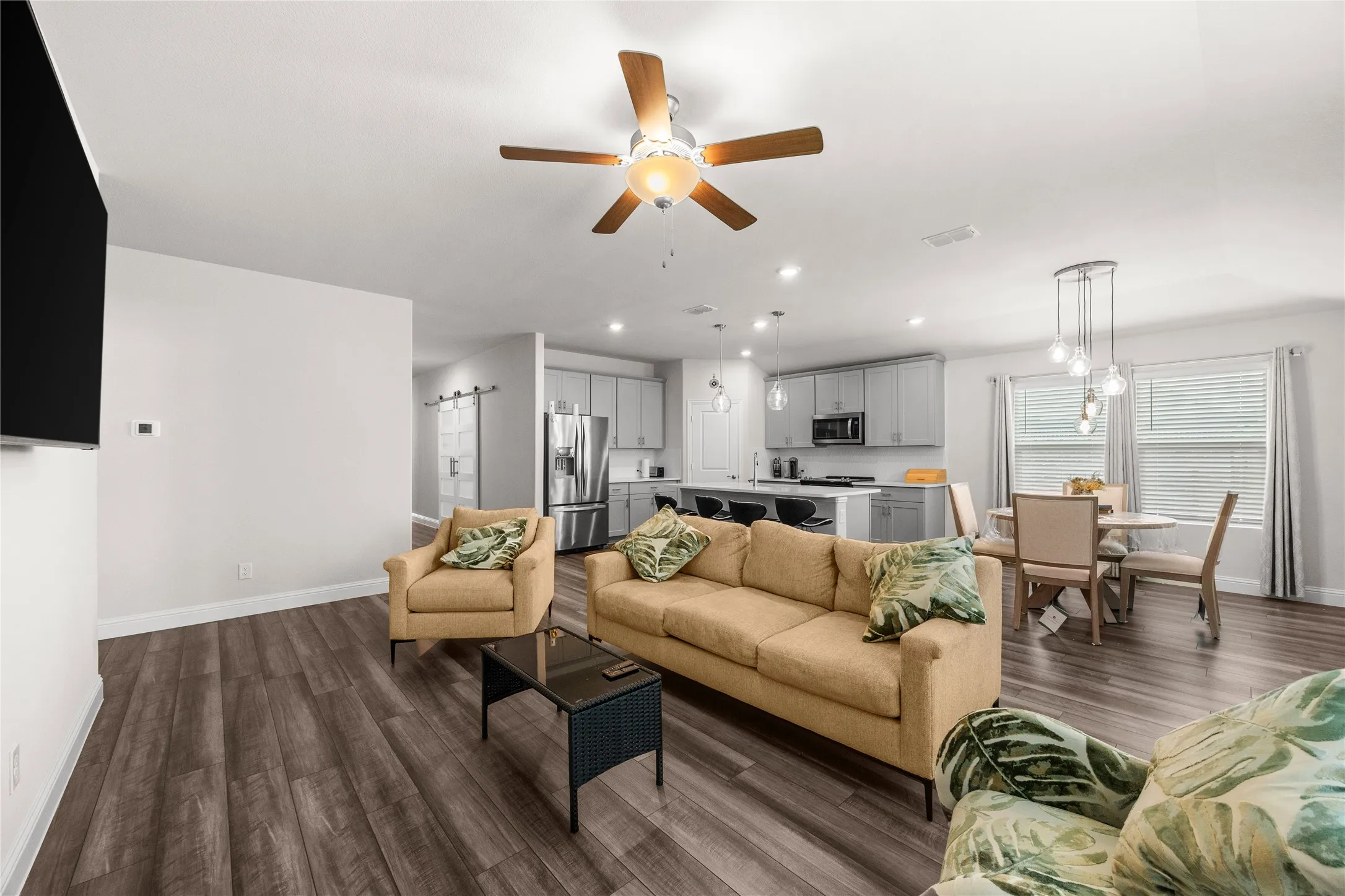 Open-concept living space featuring wood-finish flooring, a ceiling fan with integrated lighting, and recessed​​‌​​​​‌​​‌‌​‌‌​​​‌‌​‌​‌​‌​​​‌​​ lighting