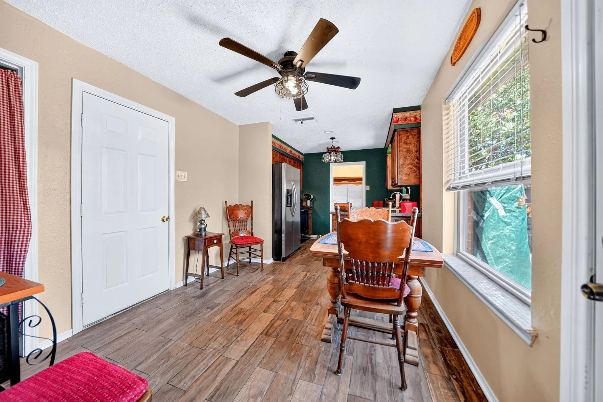 Wood-finish flooring throughout, ceiling fan with integrated lighting, recessed lighting, and a window with blinds