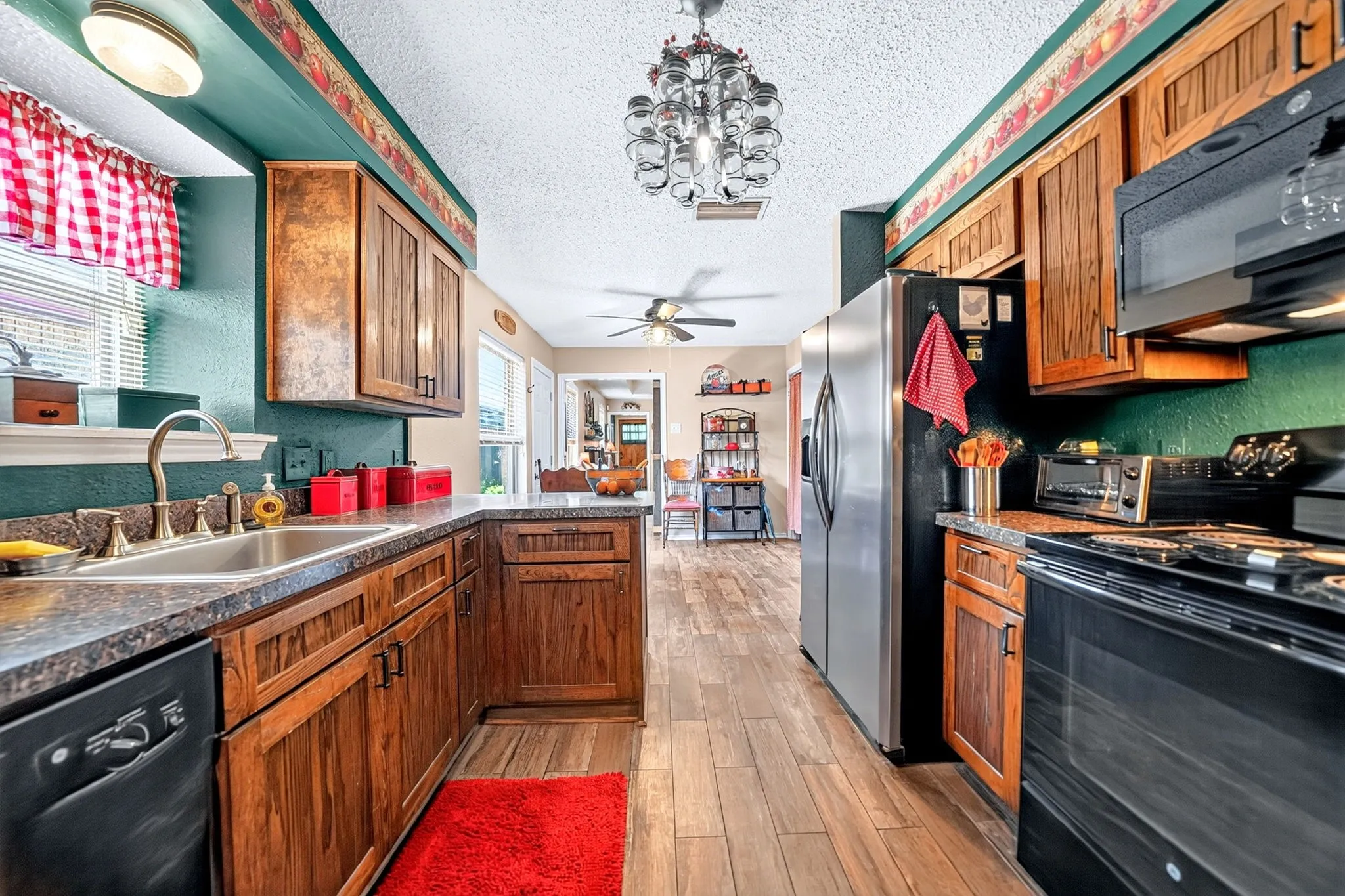 Wood-finish flooring, wood cabinetry, built-in dishwasher, built-in microwave, and stainless steel refrigerator