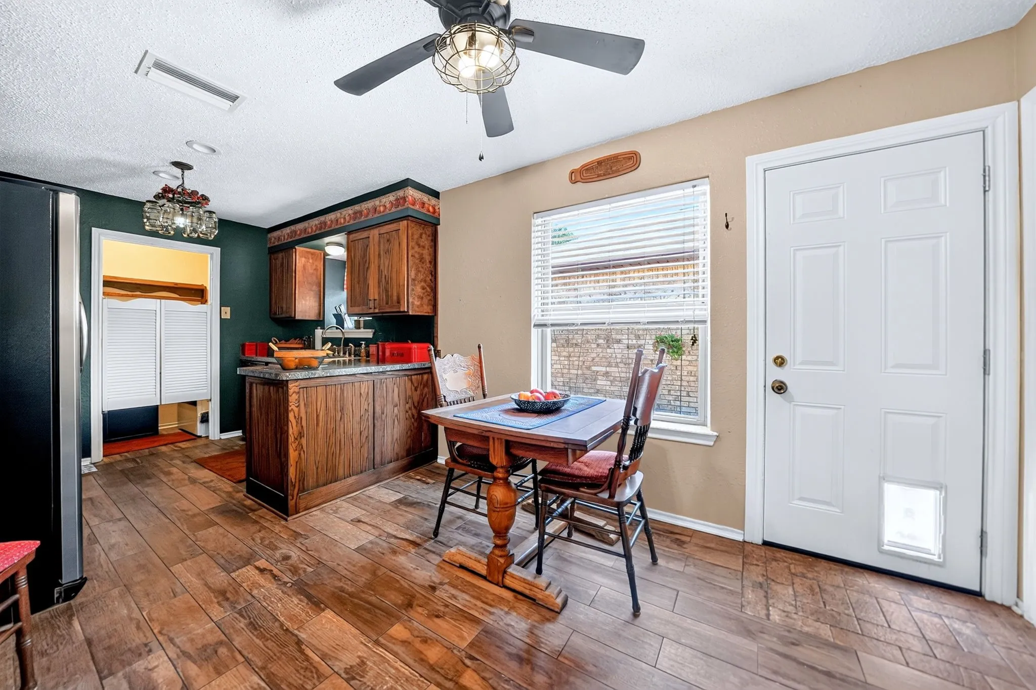 Wood-finish flooring throughout, featuring a functional island with a sink and wood cabinetry