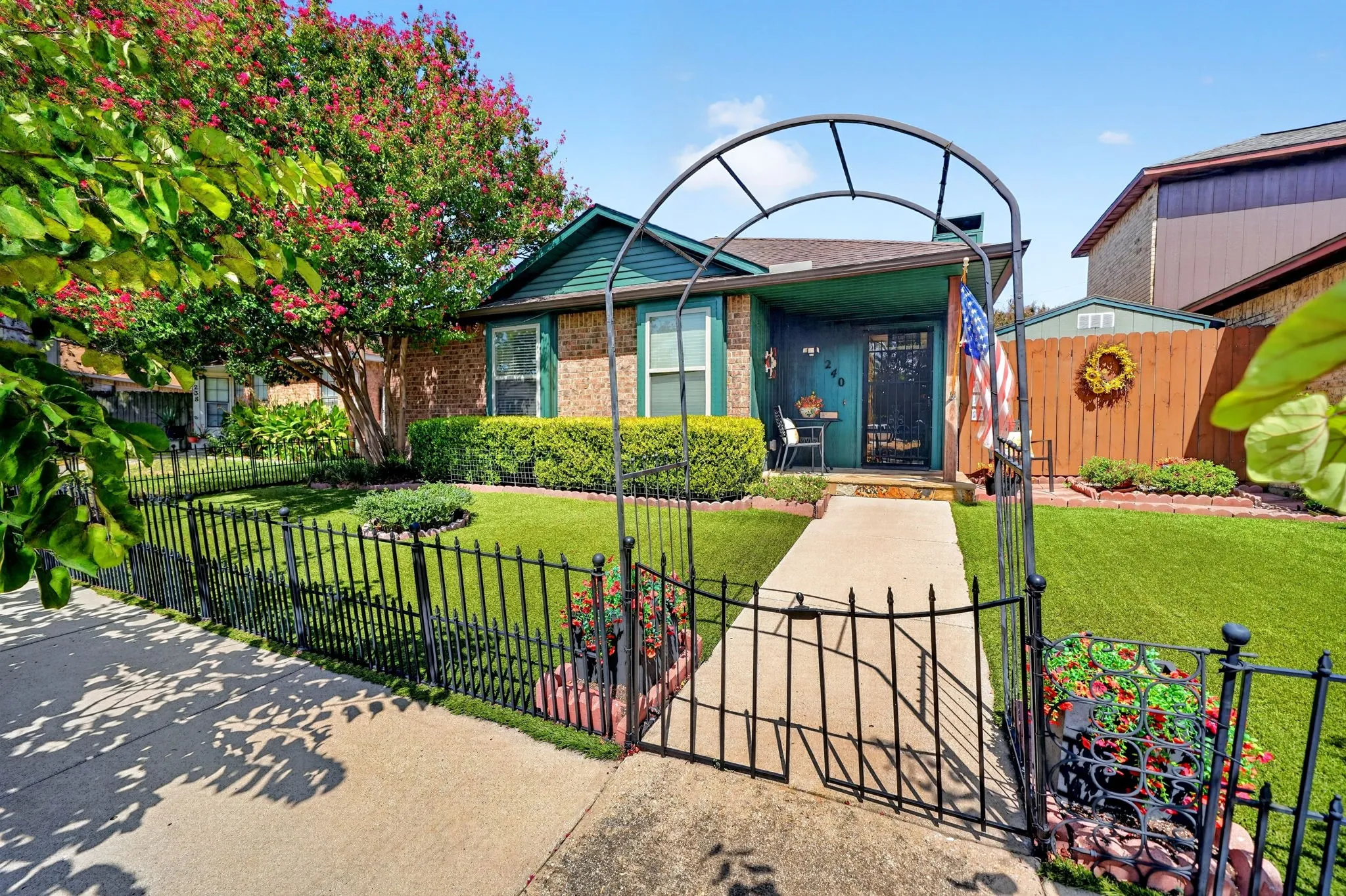 Fenced front yard with a decorative archway entrance