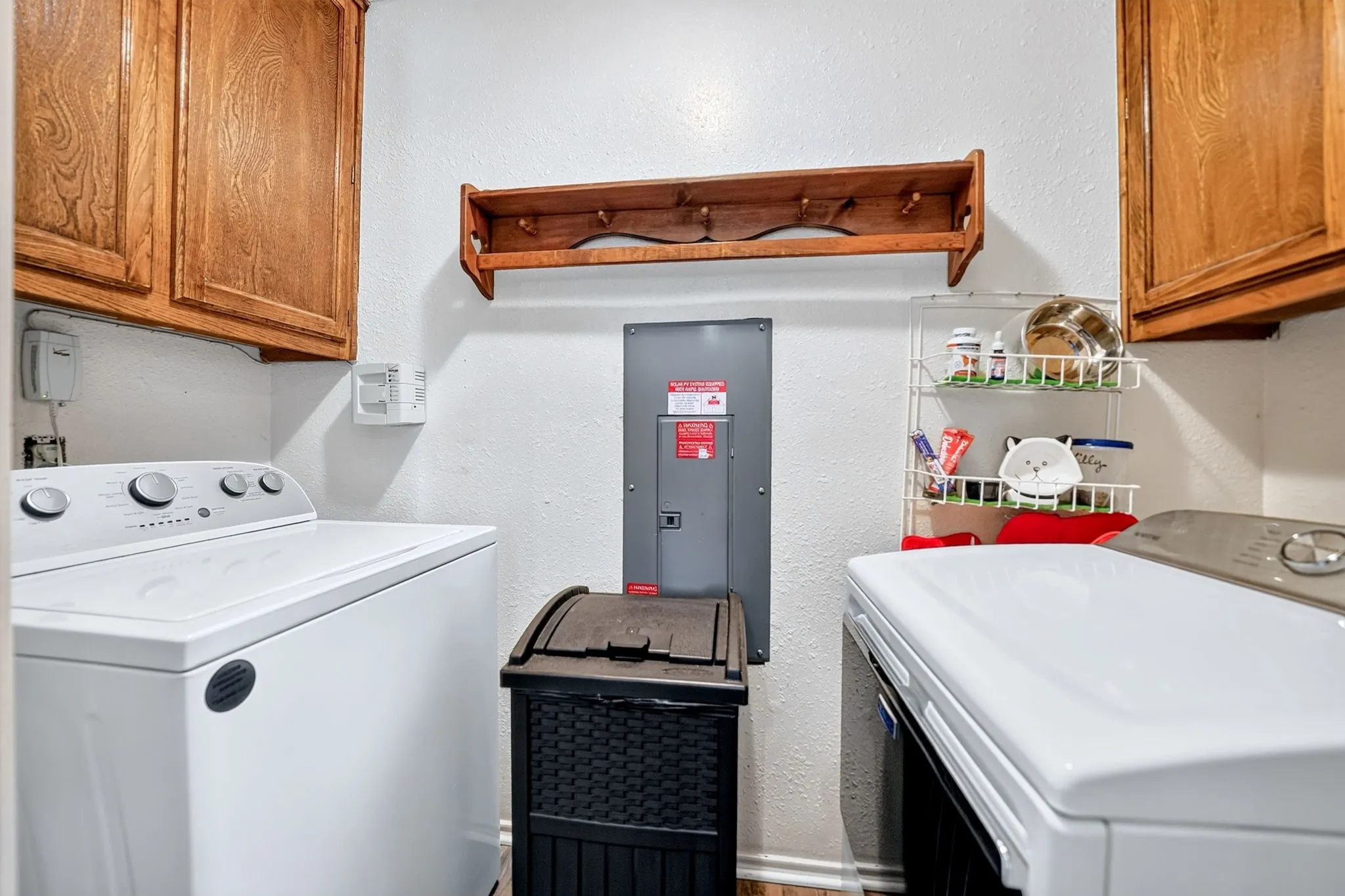 Wood-finish cabinetry offers storage with a wall-mounted wooden rack